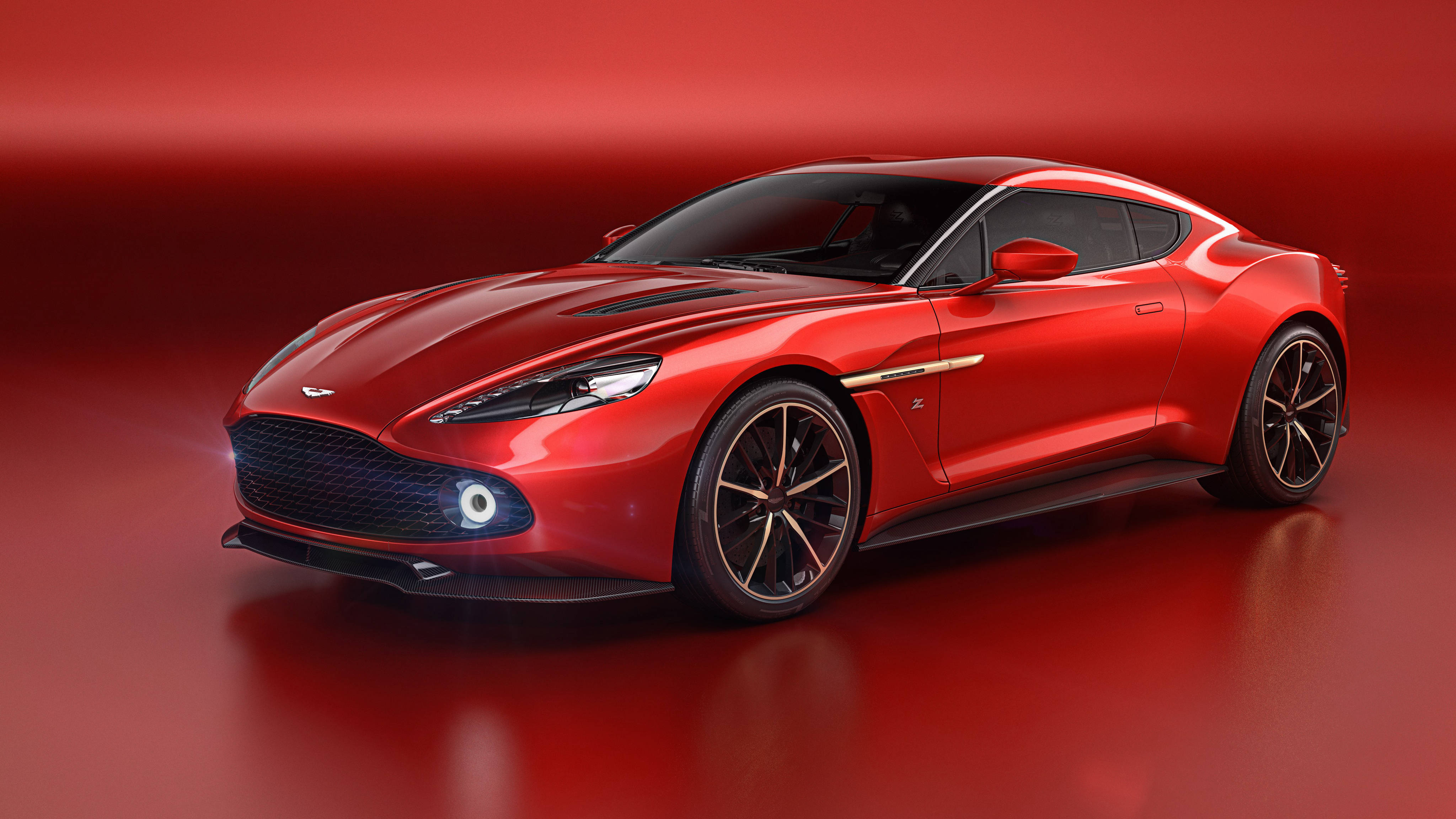 美學 桌布 壁紙 — 一輛時尚的紅色Aston Martin跑車在攝影棚燈光下閃閃發光，背景是匹配的紅色漸變色。