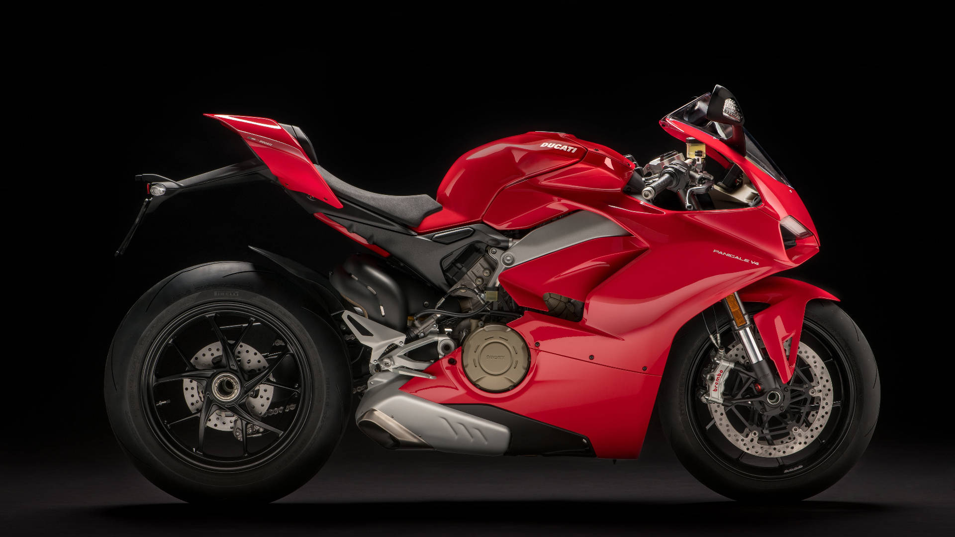杜卡迪 桌布 壁紙 — 一輛時尚的紅色Ducati Panigale V4摩托車在純黑色背景下於攝影棚燈光下閃閃發光。