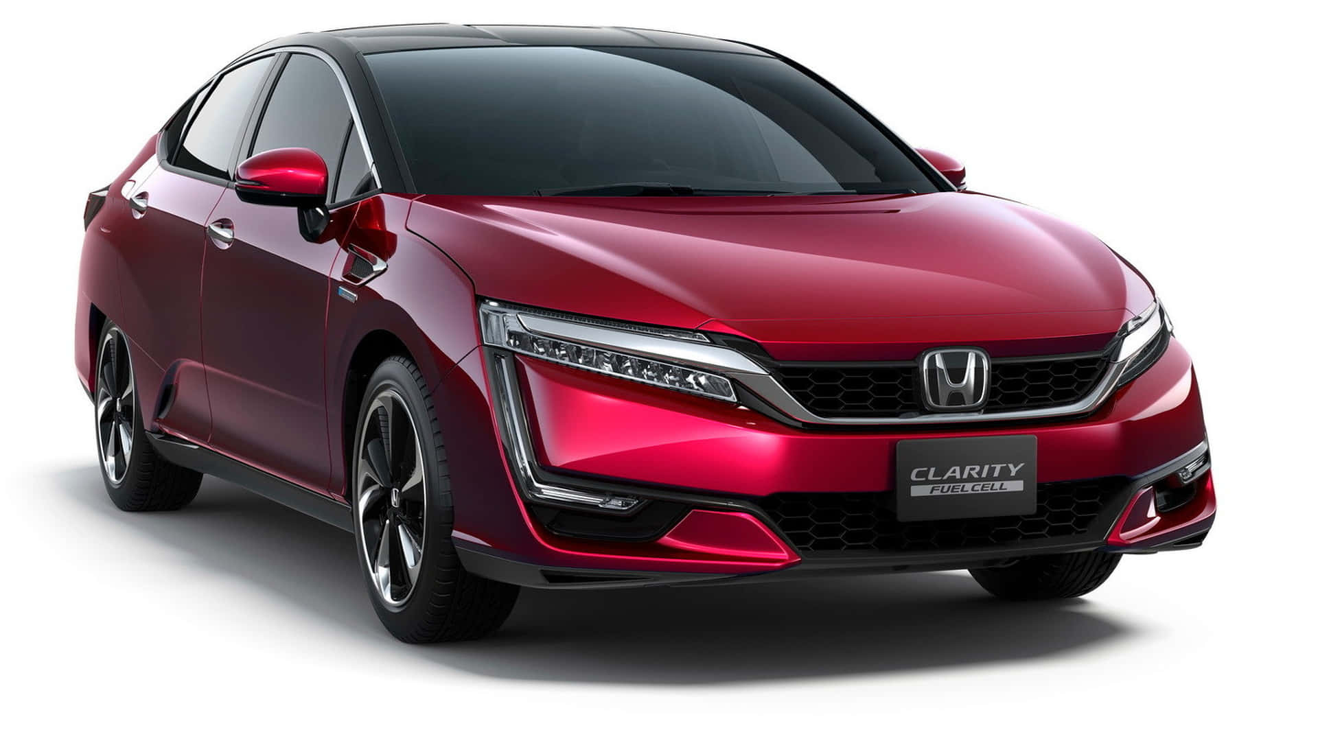 Honda Clarity 桌布 壁紙 — 一輛時尚的紅色Honda Clarity Fuel Cell轎車在攝影棚燈光下閃耀，線條銳利，車頭燈現代化。