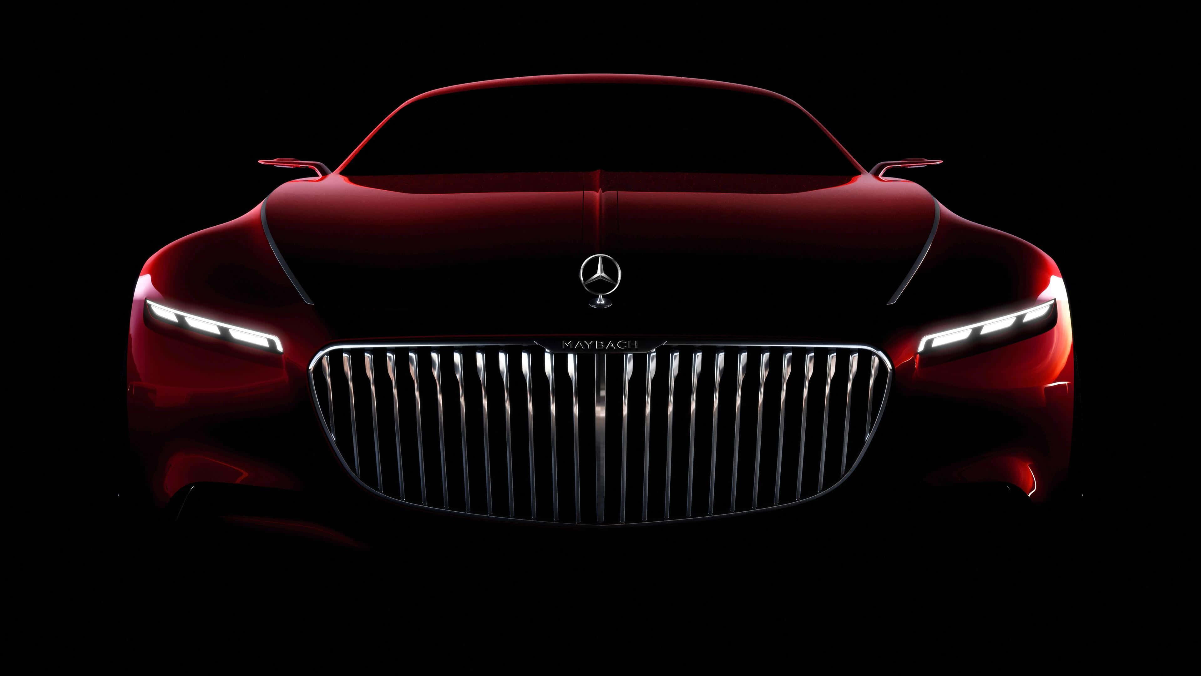 Mercedes 桌布 壁紙 — 一輛時尚的紅色Maybach概念車在漆黑背景下閃耀著銳利的車頭燈。