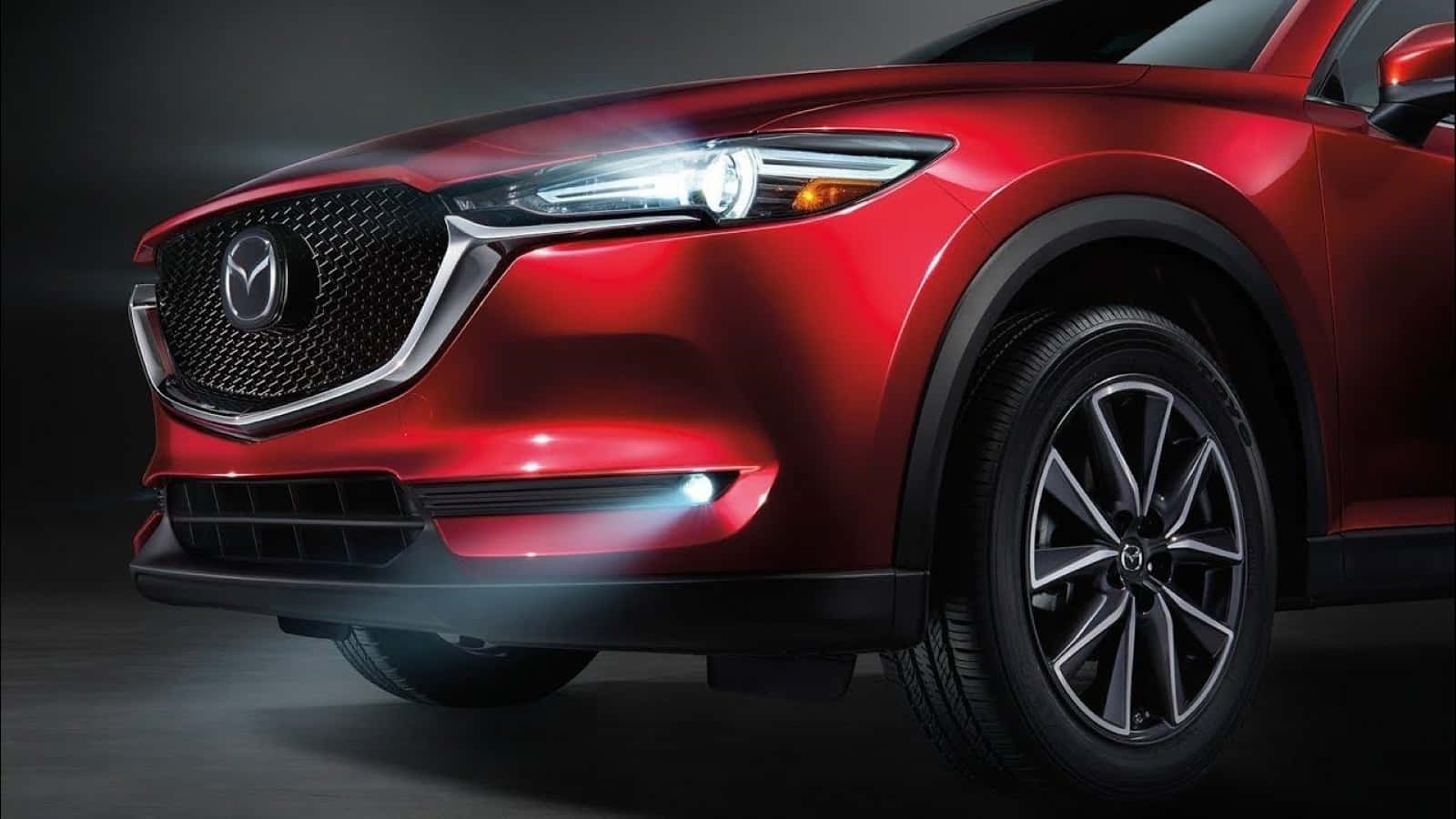 Mazda Cx-30 桌布 壁紙 — 一輛時尚的紅色Mazda SUV在攝影棚燈光下閃耀，配備銳利頭燈和時尚合金輪圈。