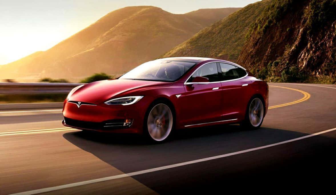 Hybrid Car 桌布 壁紙 — 一輛時尚的紅色Tesla Model S沿著蜿蜒的山路行駛，沐浴在金色的夕陽光中。