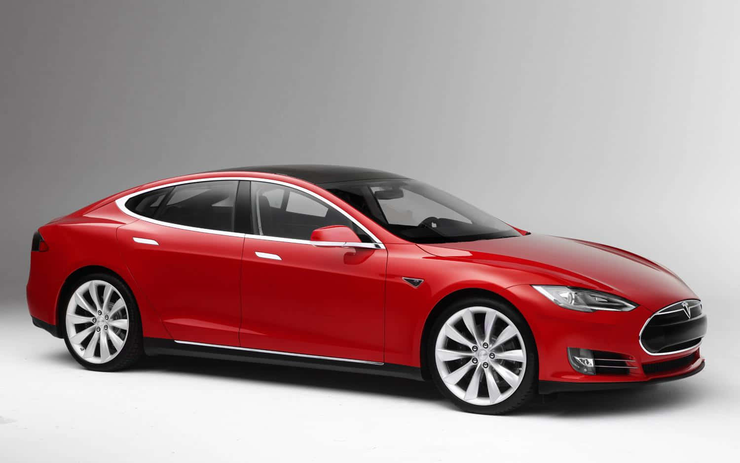Tesla Model 3 桌布 壁紙 — 一輛時尚的紅色Tesla Model S轎車，配備黑色車頂和銀色輪圈，置於簡約風格的攝影棚中。