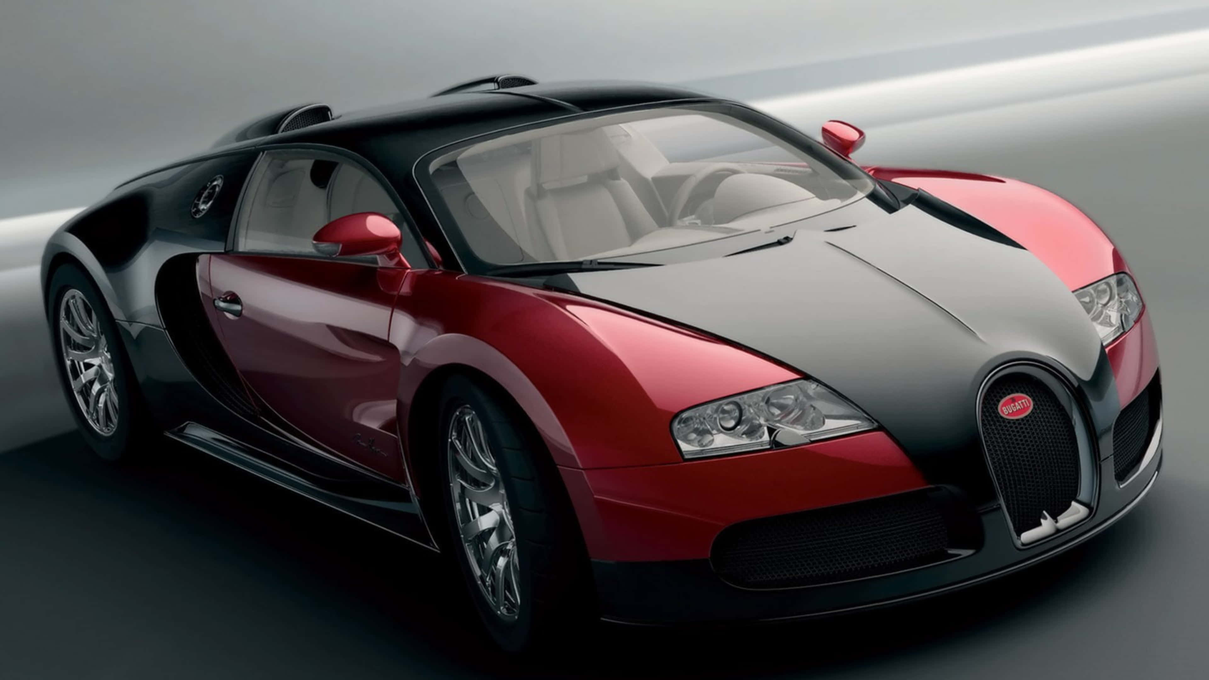 桌布 壁紙 — 一輛時尚的紅色和黑色Bugatti Veyron跑車在工作室燈光下閃閃發光，採用動態低角度拍攝。