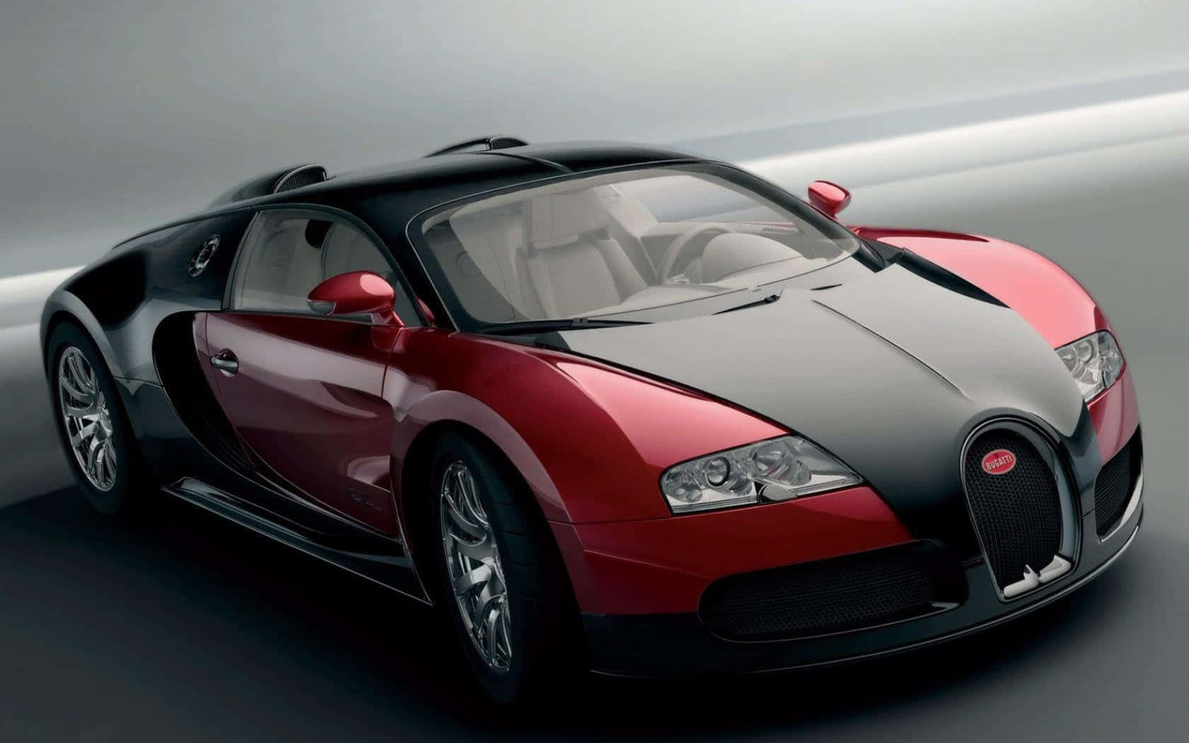 Bugatti Veyron 桌布 壁紙 — 一輛時尚的紅色和黑色布加迪威龍跑車在工作室燈光下閃閃發光，背景模糊動感。