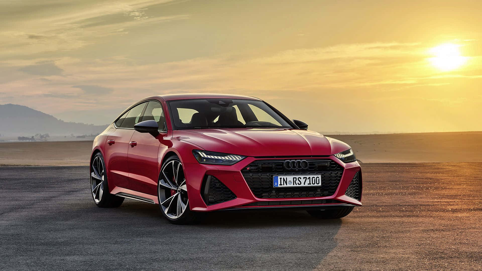 Audi S7 桌布 壁紙 — 一輛時尚的紅色奧迪RS7跑車停在日落時分的瀝青路上，金色陽光投下長長的影子。