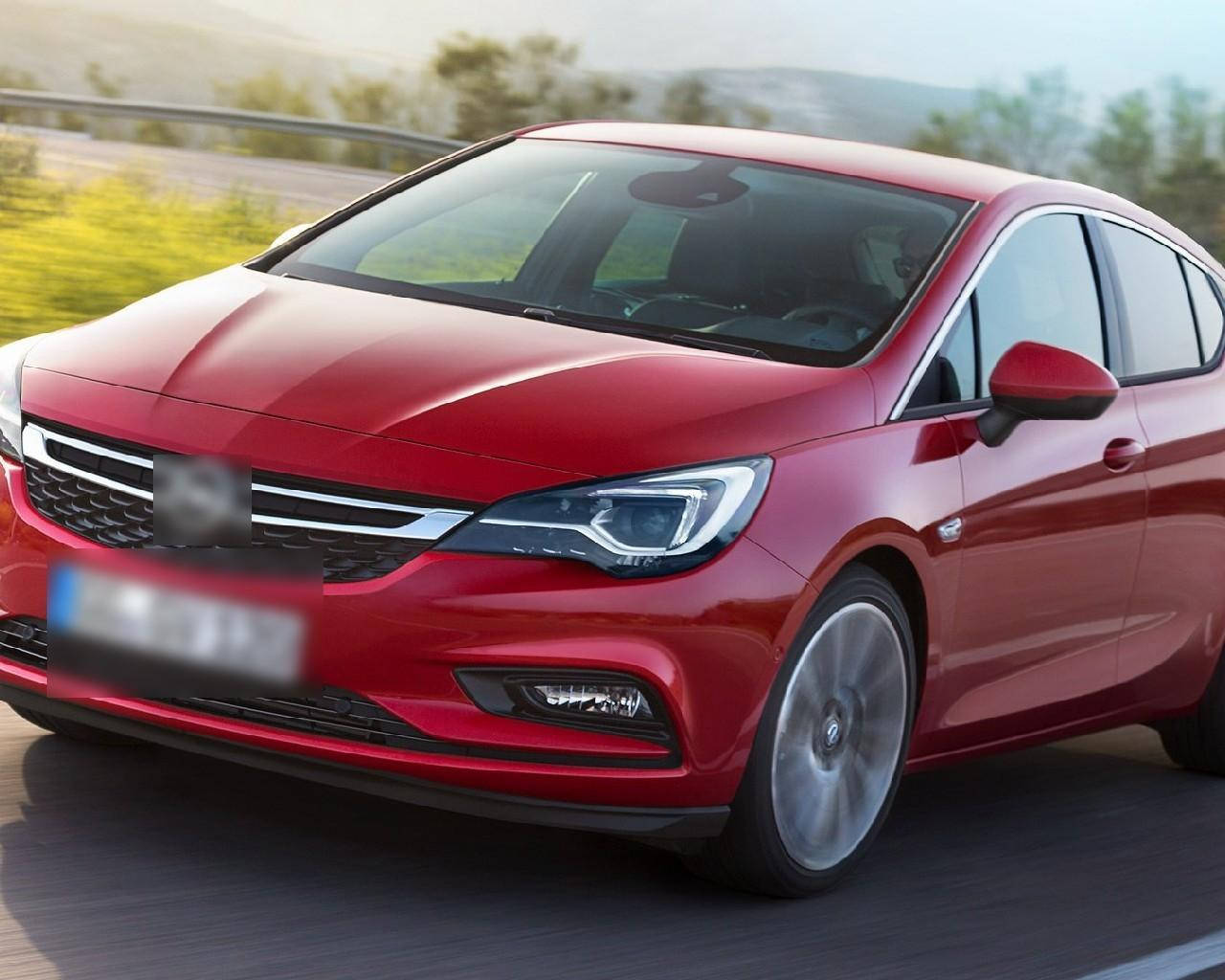 Opel 桌布 壁紙 — 一輛時尚的紅色掀背車在陽光明媚的高速公路上飛馳，背景是模糊的綠色植物和山丘。