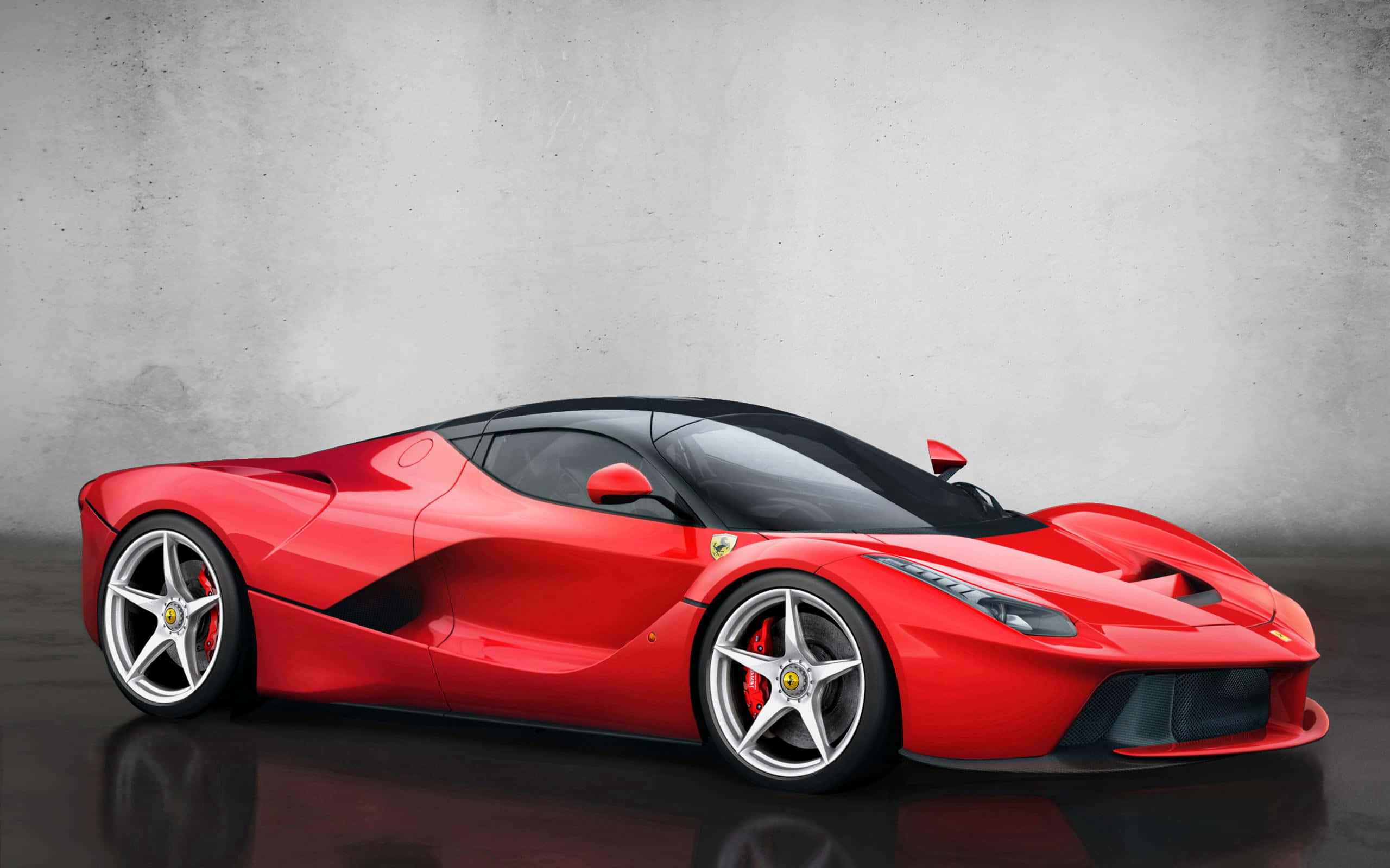 Ferrari Laferrari 桌布 壁紙 — 一輛時尚的紅色法拉利 LaFerrari 跑車，帶有黑色飾邊和銀色輪圈，停在反光的深色地板上，背景是帶有紋理的灰色牆壁。