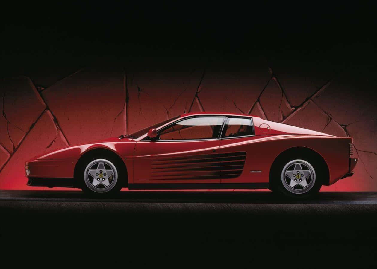 Ferrari Testarossa 桌布 壁紙 — 一輛時尚的紅色法拉利 Testarossa 在戲劇性的工作室燈光下，在裂開的紅牆前閃耀。