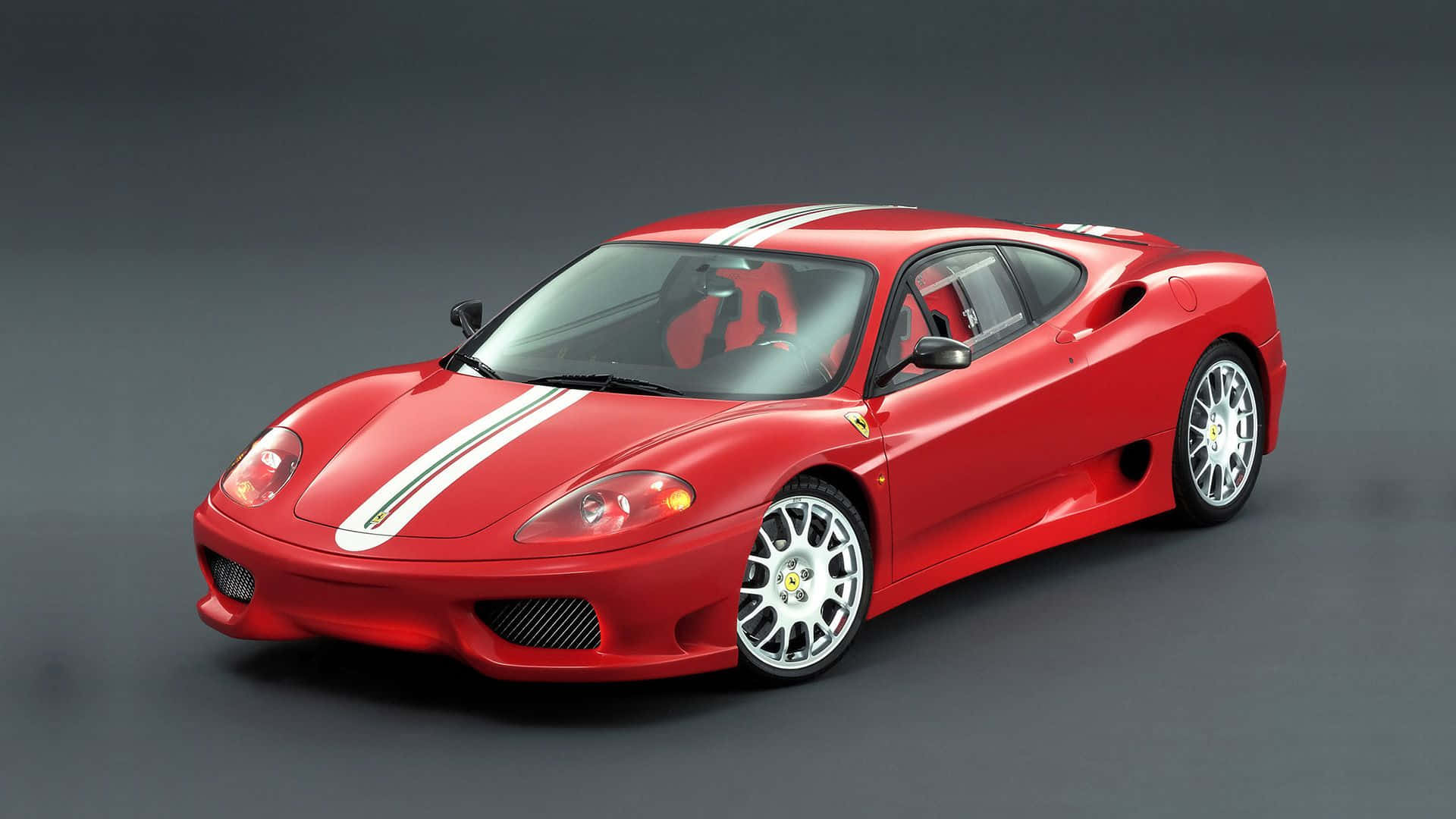 Ferrari 360 Modena 桌布 壁紙 — 一輛時尚的紅色法拉利360跑車，帶有白色賽車條紋，在深灰色背景的攝影棚中展示。