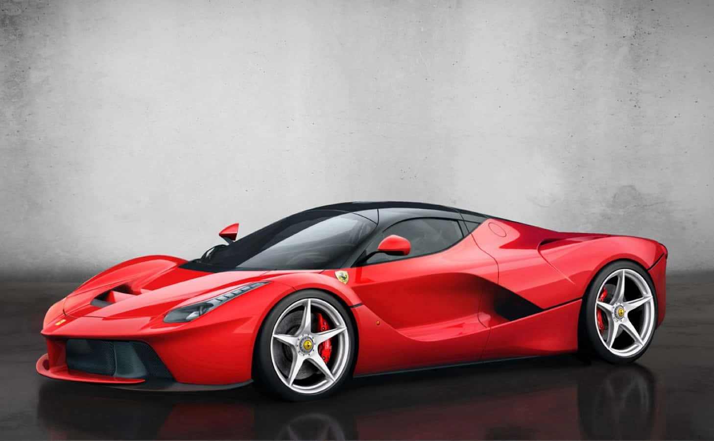 Ferrari Enzo 桌布 壁紙 — 一輛時尚的紅色法拉利LaFerrari跑車，帶有黑色飾邊和銀色輪圈，在帶有反射地板的紋理灰色工作室牆壁前展示。