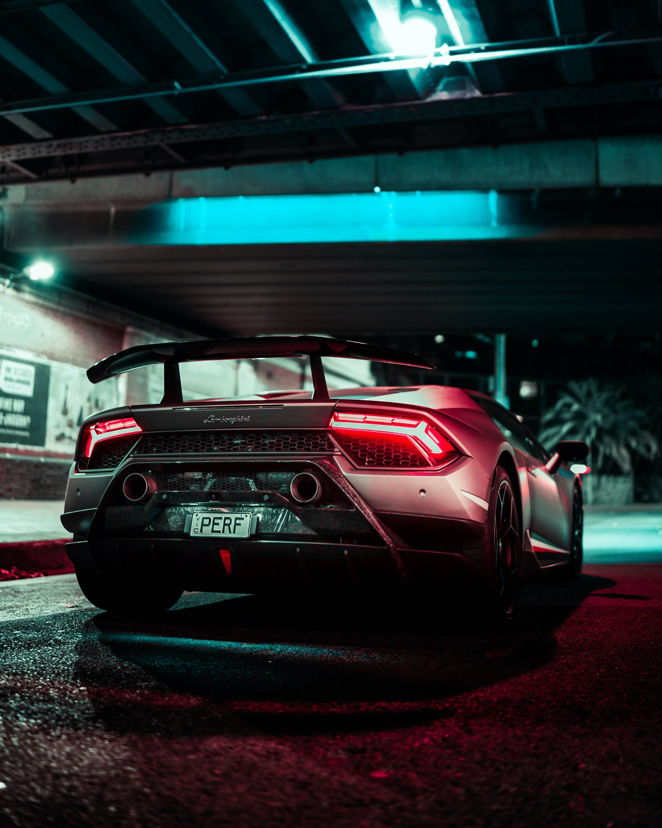 桌布 壁紙 — 一輛時尚的紅色藍寶堅尼 Huracán Performante 在夜間停泊在橋下，帶有發光的紅色尾燈和藍色環境照明。