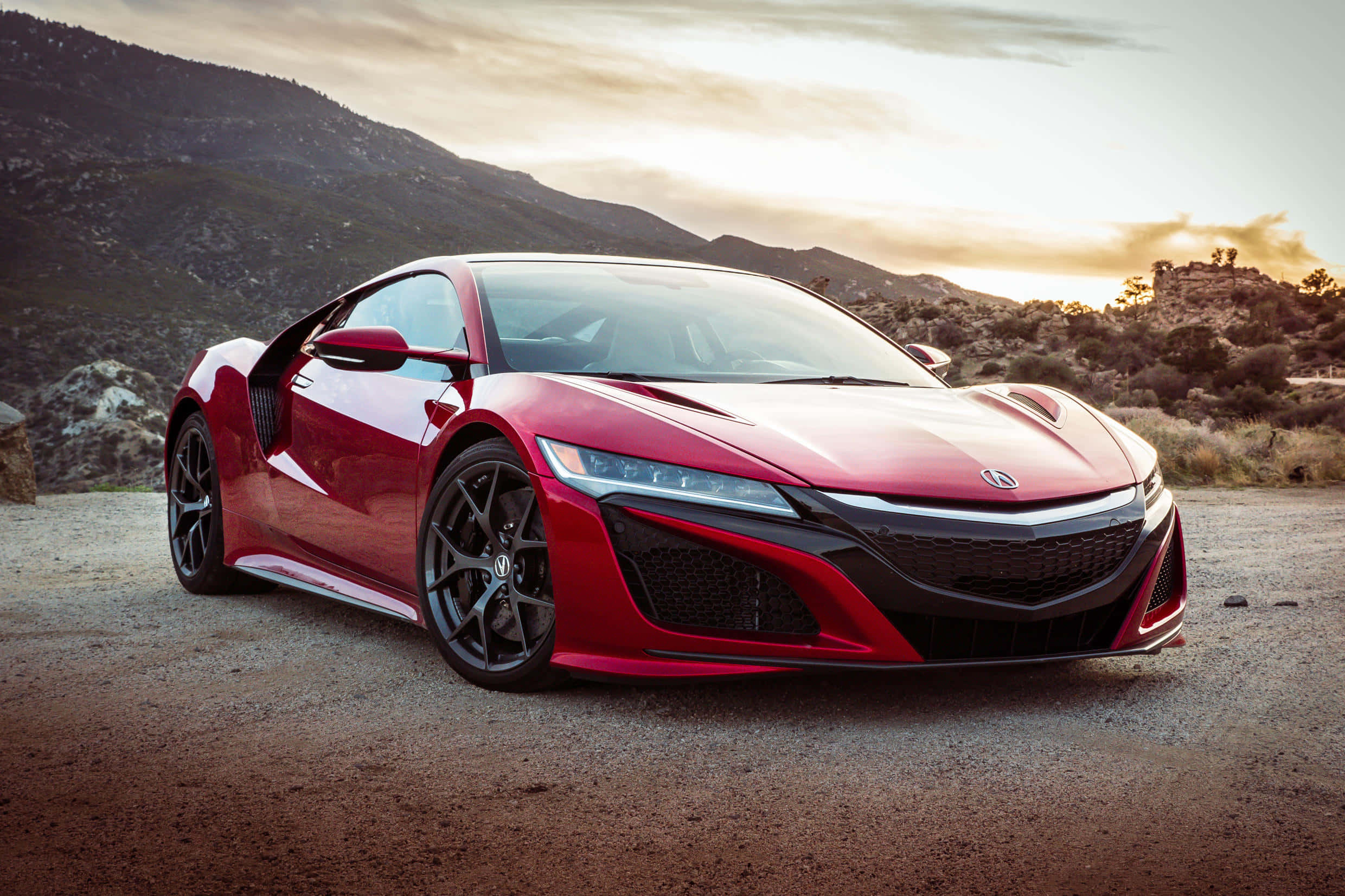 Acura 桌布 壁紙 — 一輛時尚的紅色跑車停在碎石路上，背景是日落時分的山脈。