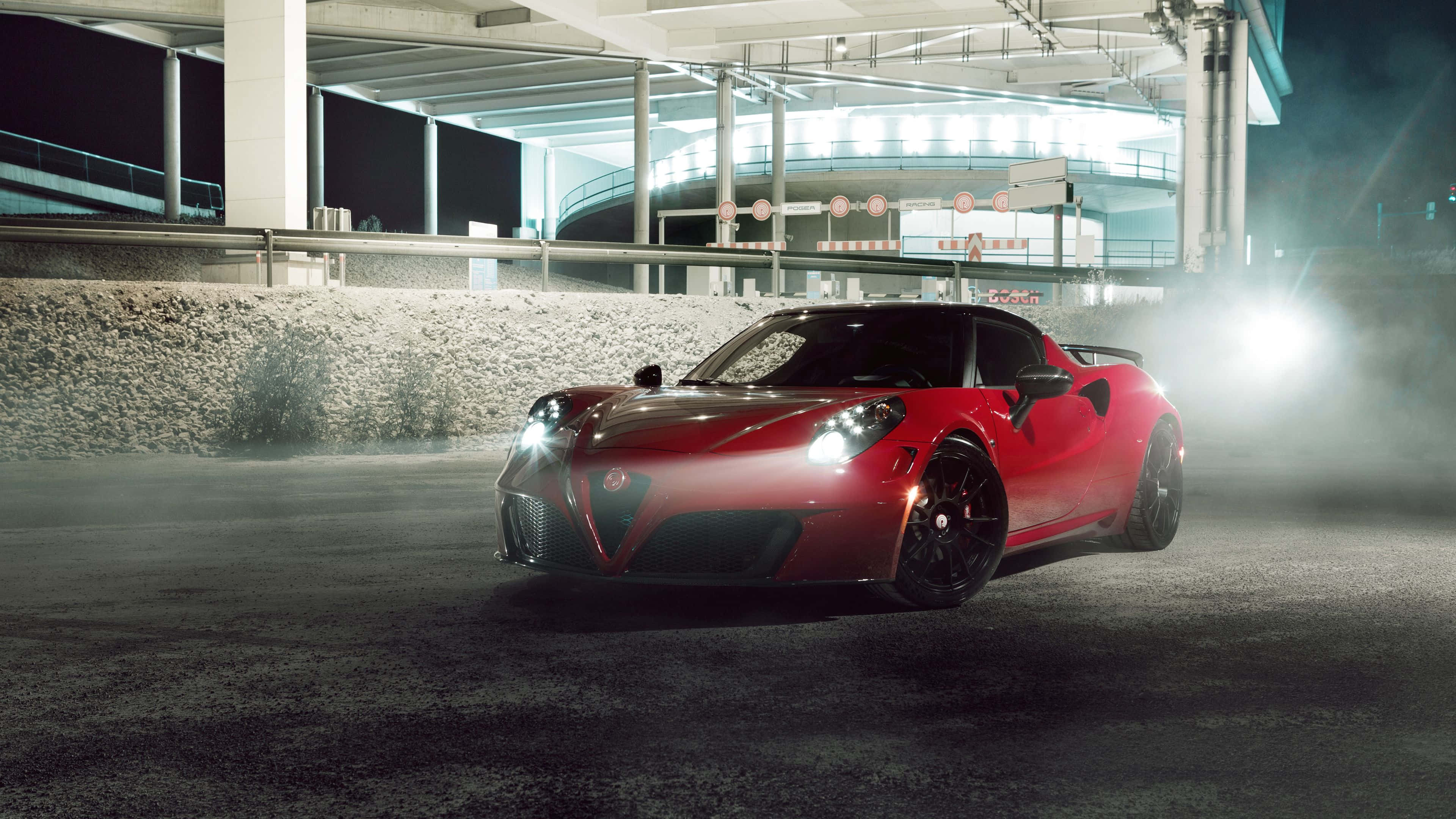 Alfa Romeo 4c 桌布 壁紙 — 一輛時尚的紅色跑車在夜間霧濛濛的地下停車場中，在明亮的車頭燈下閃耀。