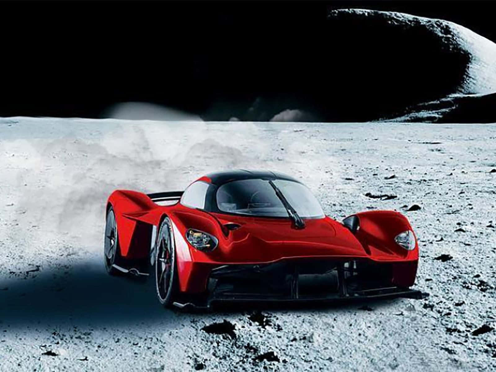 Aston Martin Valkyrie 桌布 壁紙 — 一輛時尚的紅色跑車在月光照射的月球表面高速行駛，在黑暗的天空下揚起灰塵。