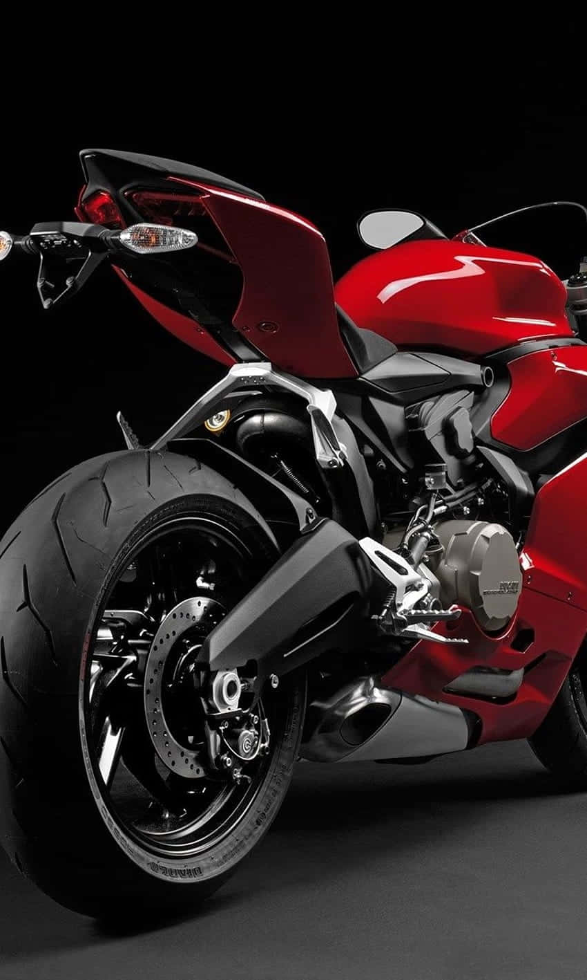 Superbike 桌布 壁紙 — 一輛時尚的紅色運動機車，帶有黑色點綴和鍍鉻細節，在深色背景下展示。