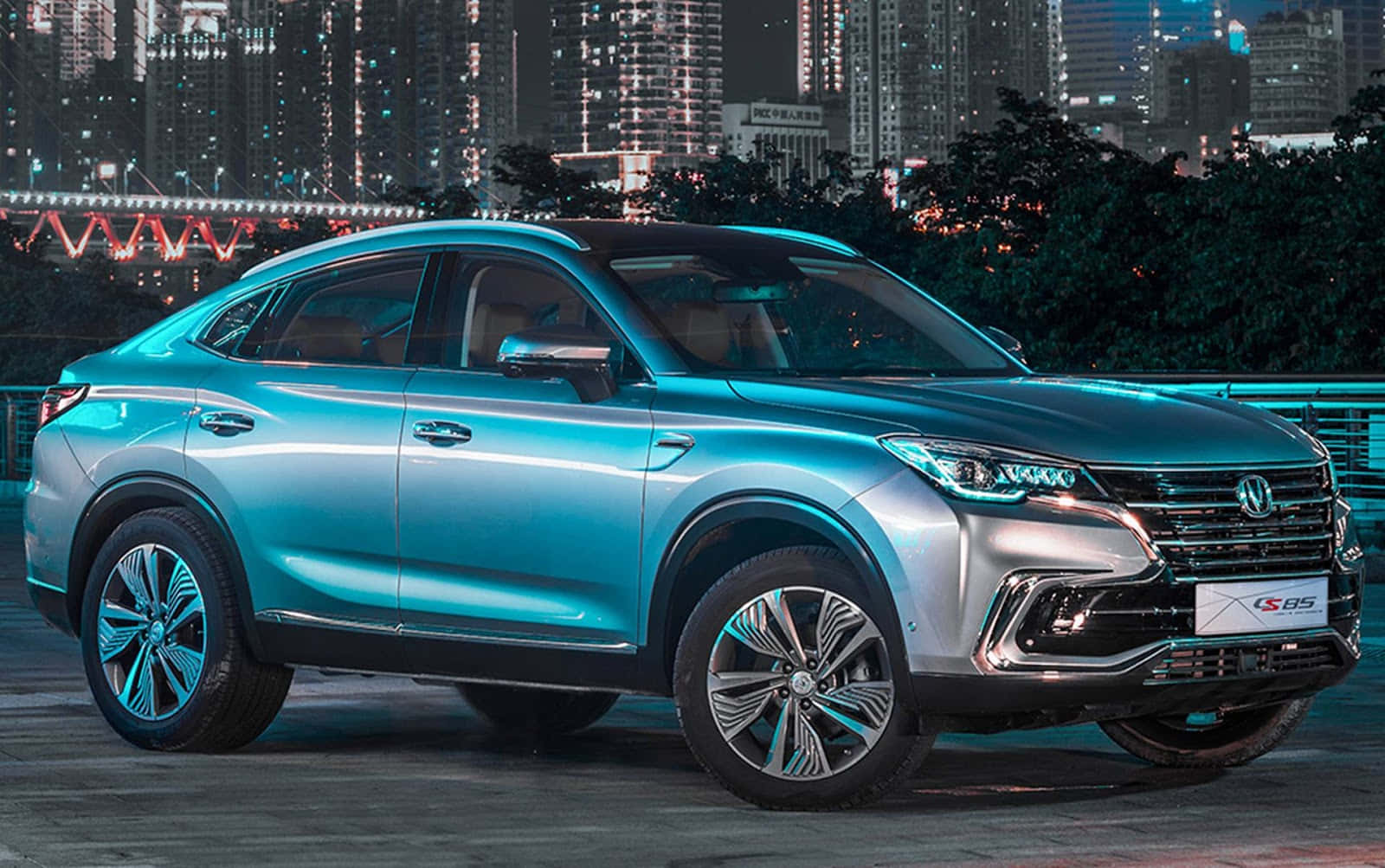 Changan 桌布 壁紙 — 一輛時尚的綠松色SUV在都市燈光下閃耀，背景是發光的橋樑和摩天大樓。