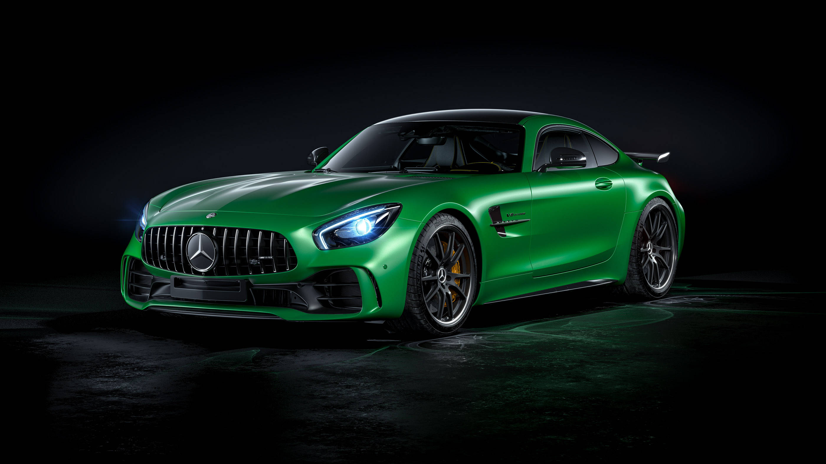 Gtr 桌布 壁紙 — 一輛時尚的綠色 Mercedes-AMG GT R 跑車在攝影棚燈光下，在深色背景中閃耀。