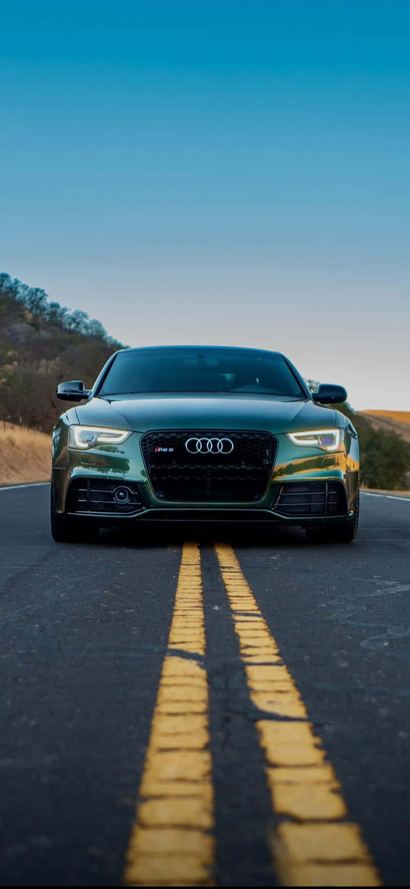 奧迪 桌布 壁紙 — 一輛時尚的綠色Audi S5在晴朗藍天下，面向雙黃線的蜿蜒道路前方。