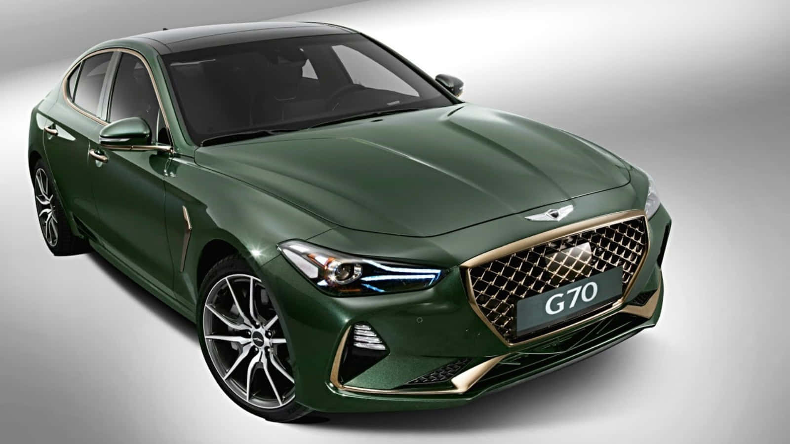 創世紀 桌布 壁紙 — 一輛時尚的綠色Genesis G70轎車，帶有金色飾邊和鋒利頭燈，在工作室環境中展示。