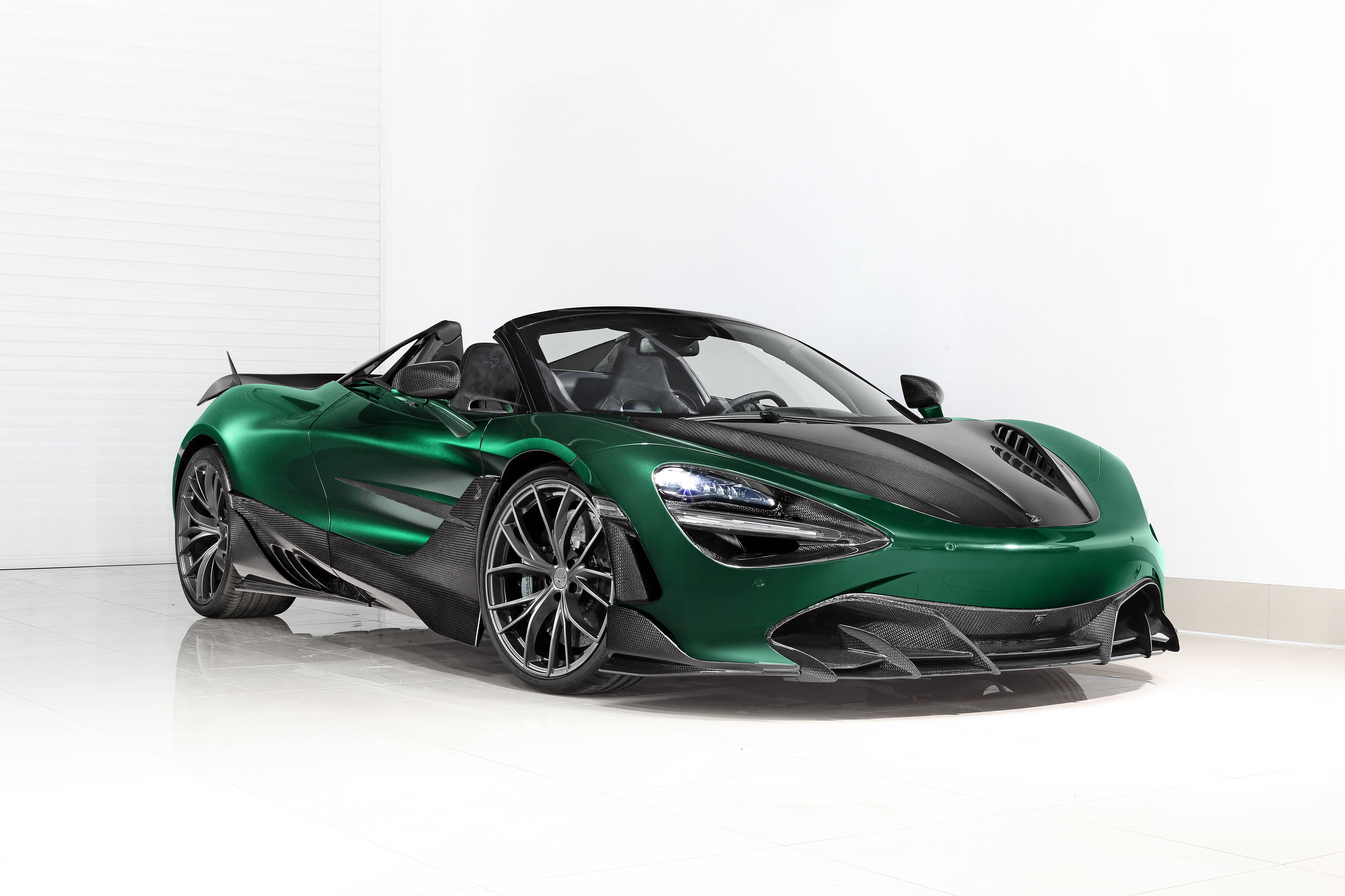 Mclaren 720s 桌布 壁紙 — 一輛時尚的綠色McLaren Speedtail敞篷跑車，帶有黑色碳纖維飾邊，在工作室燈光下於純白地板上閃閃發光。
