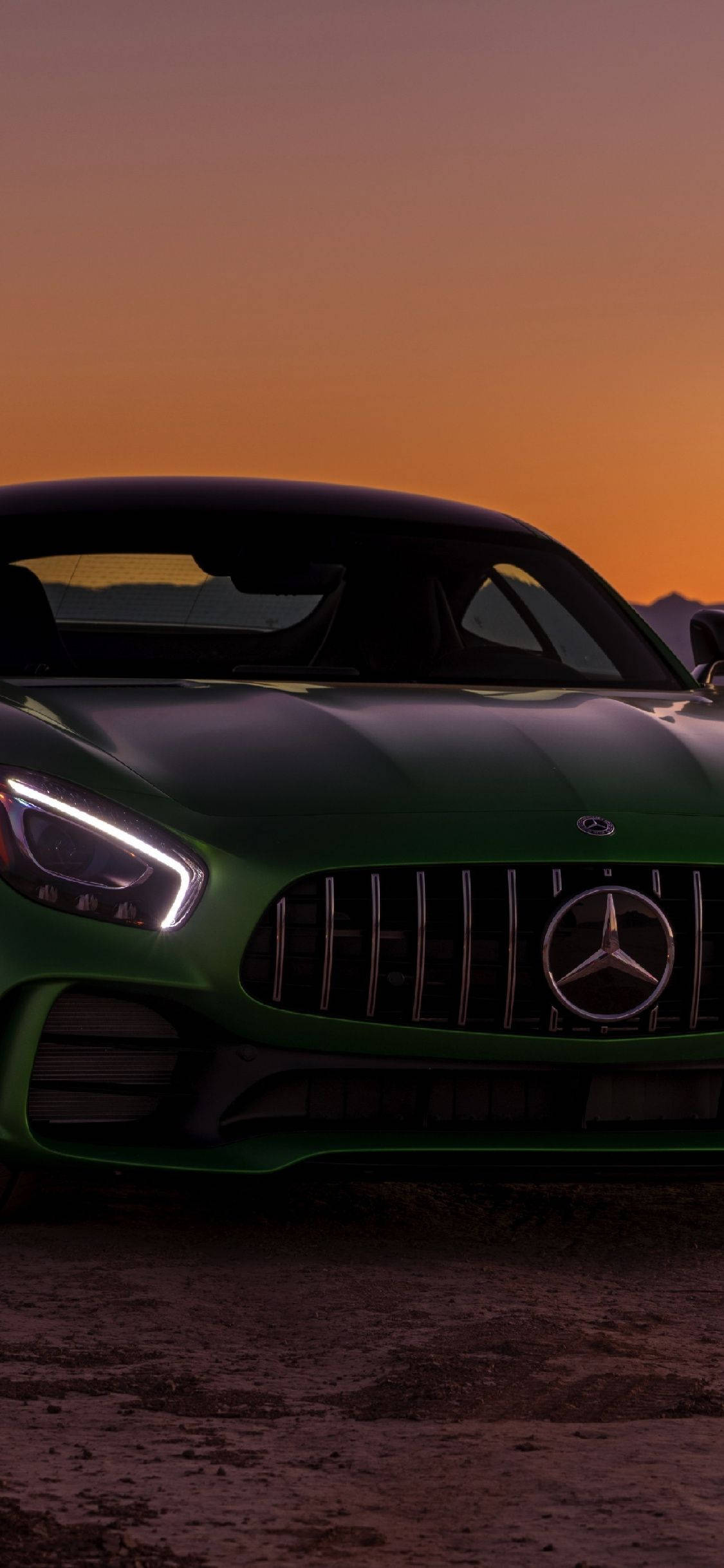 X 桌布 壁紙 — 一輛時尚的綠色Mercedes-AMG GT跑車在火熱的橙色日落天空下閃閃發光。