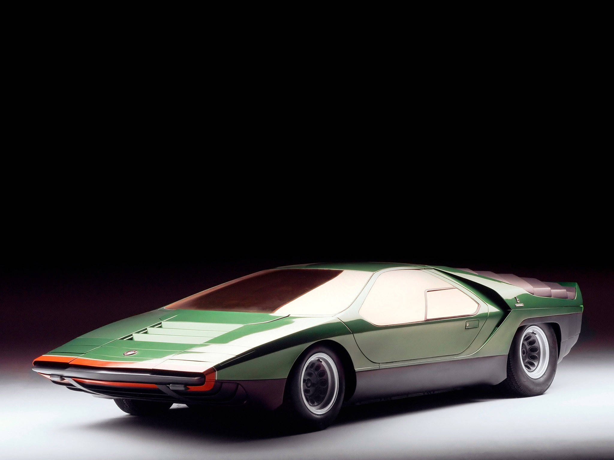 alfa romeo iPhone 桌布 壁紙 — 一輛時尚的綠色和白色未來主義跑車，帶有橙色點綴，在黑色背景的攝影棚燈光下閃耀。