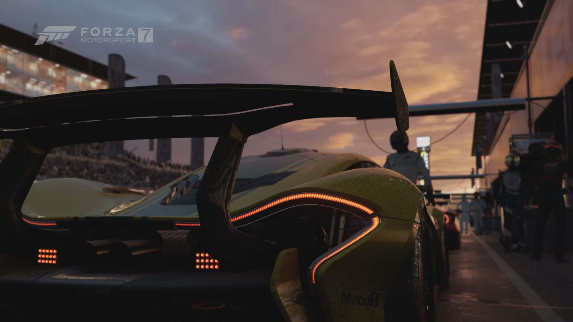 Mclaren P1 桌布 壁紙 — 一輛時尚的綠色賽車帶有發光的橙色燈光，在黃昏時停在維修區車道，背景是人群。