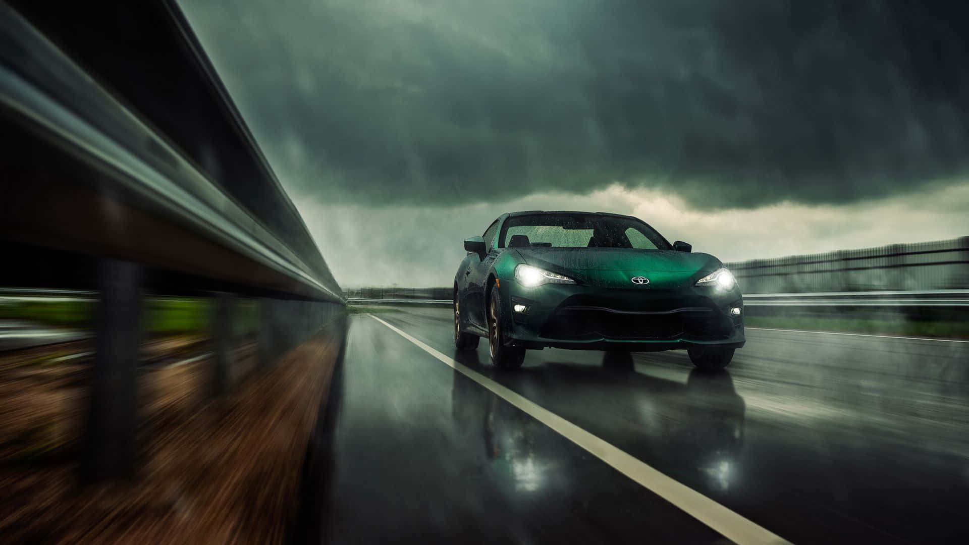 綠色跑車在潮濕高速公路上於暴風雨天空下疾馳。 — Toyota Supra Mk4 壁紙