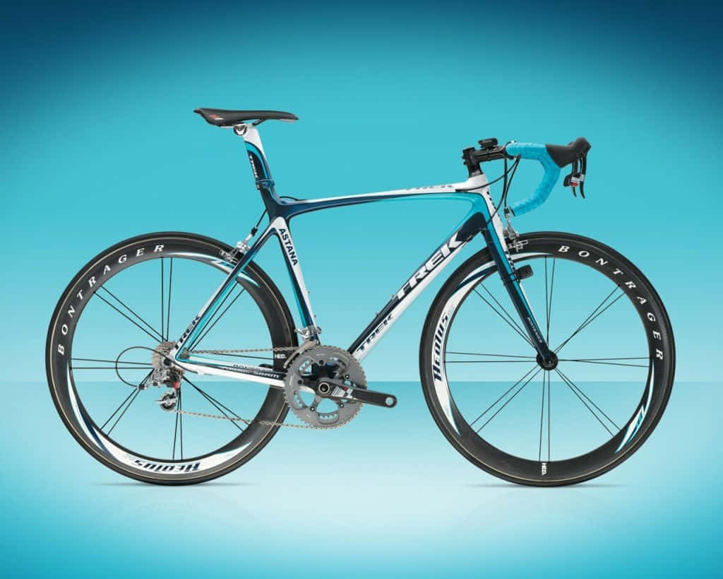 Bikes 桌布 壁紙 — 一輛時尚的藍白色Trek公路自行車，配備Bontrager輪組，在青綠色漸變背景前蓄勢待發。