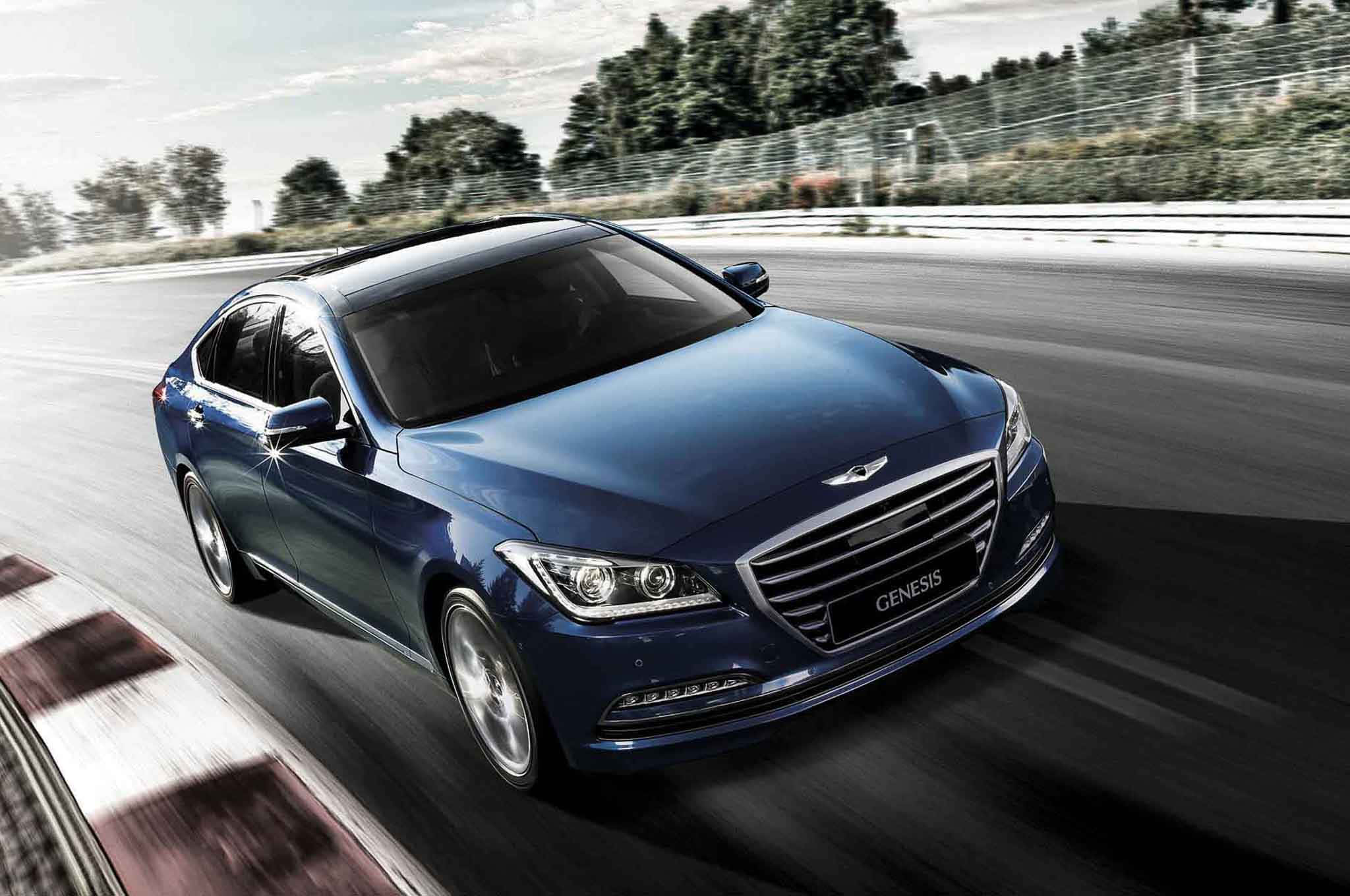 Genesis 桌布 壁紙 — 一輛時尚的藍色 Genesis 轎車在賽道上疾馳，動態模糊強調其動態性能。