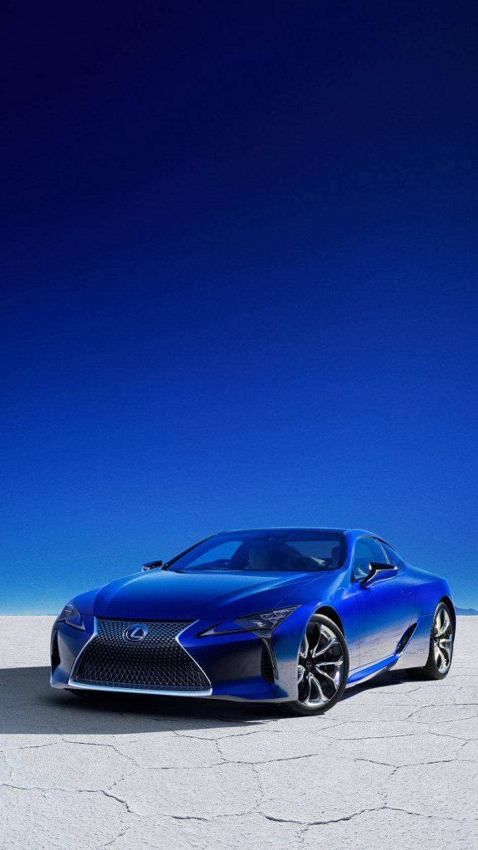 凌志 桌布 壁紙 — 一輛時尚的藍色 Lexus 跑車在明亮的陽光下閃閃發光，停在龜裂的白色沙漠地面上，上方是廣闊的深藍色天空。