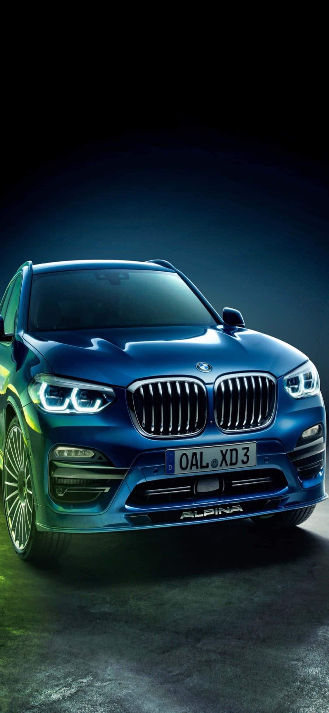 iPhone X Bmw 桌布 壁紙 — 一輛時尚的藍色Alpina BMW SUV在戲劇性的工作室燈光下，在黑暗的背景中閃耀。