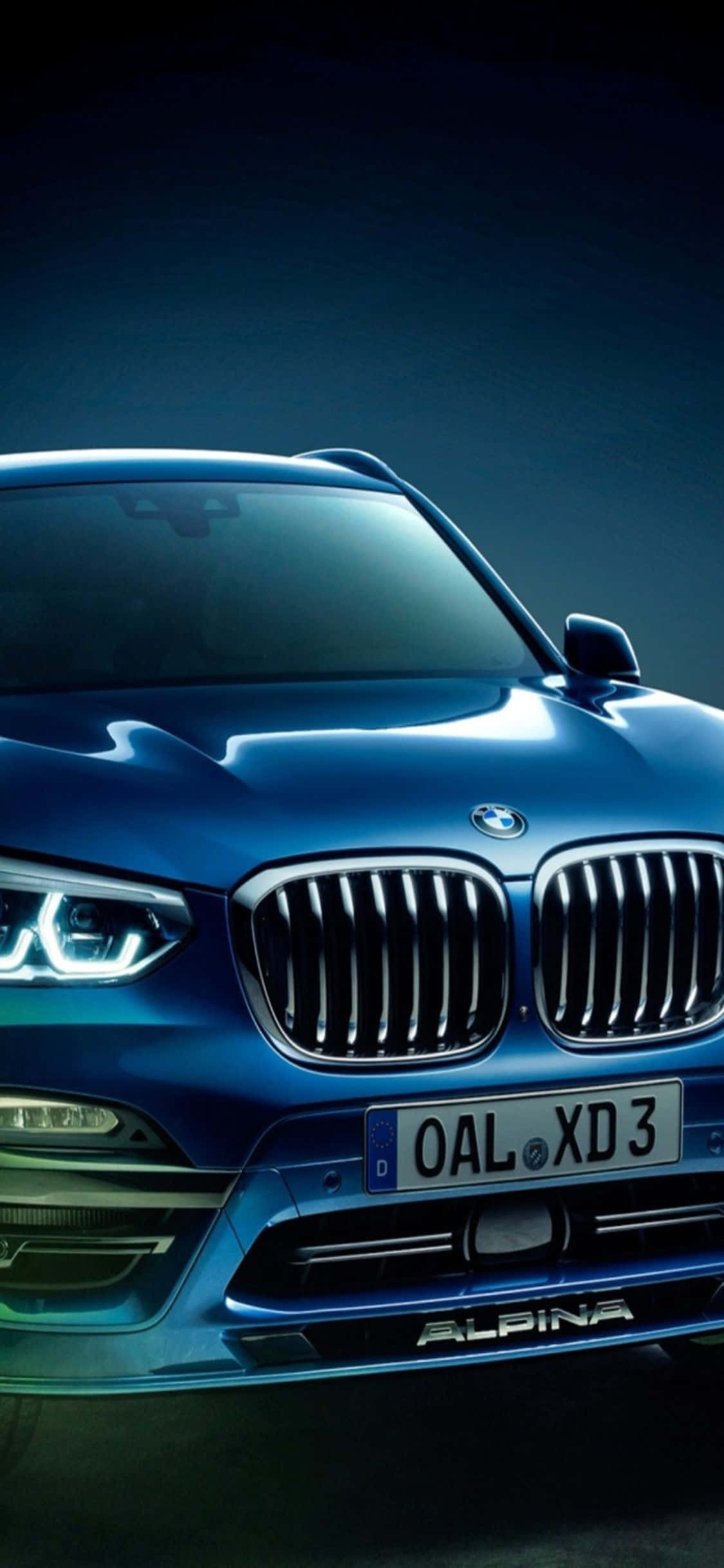 iPhone X Bmw 桌布 壁紙 — 一輛時尚的藍色BMW Alpina XD3 SUV在戲劇性的工作室燈光下閃耀，拋光表面反射出銳利的光芒。