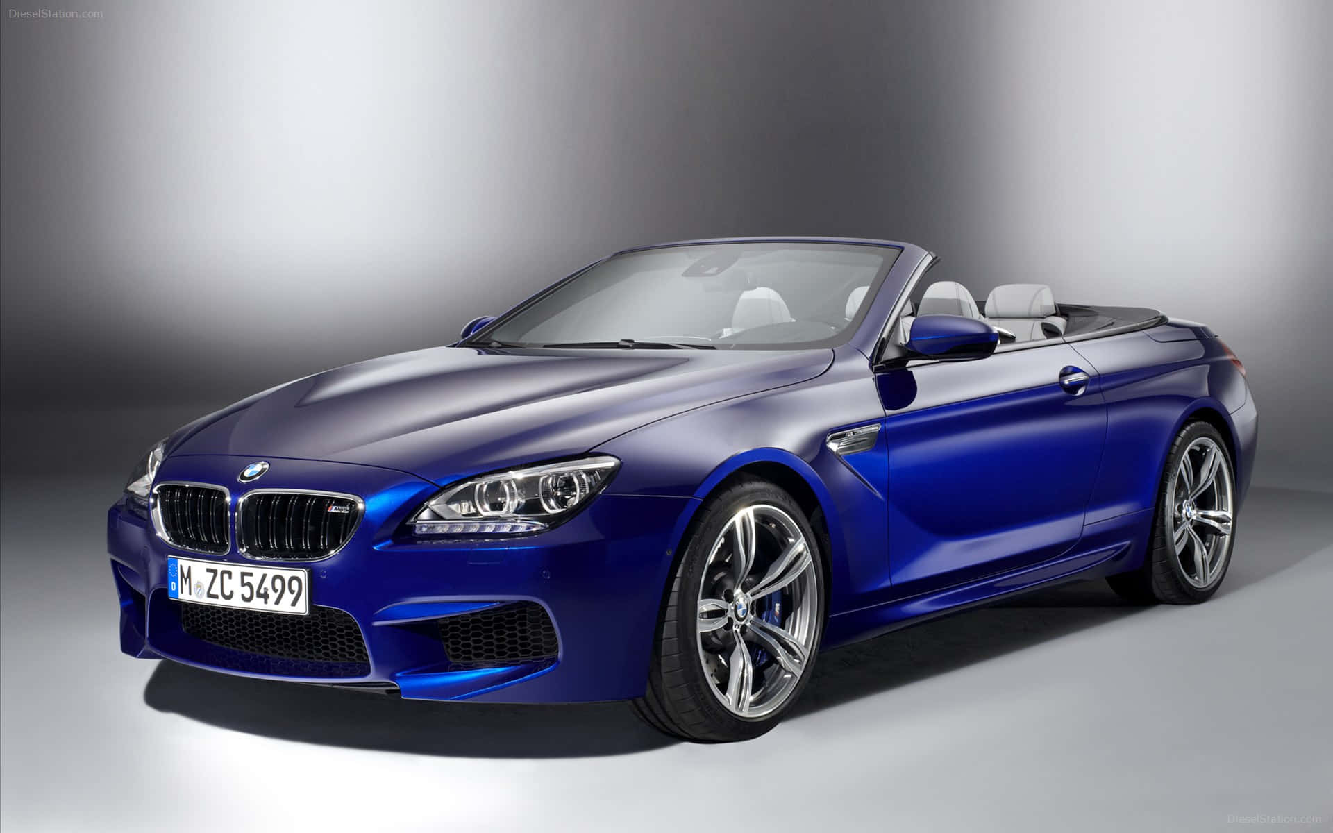 Bmw M6 桌布 壁紙 — 一輛時尚的藍色BMW M6敞篷車，配備白色內飾和銀色輪圈，在漸變灰色背景的攝影棚中展示。