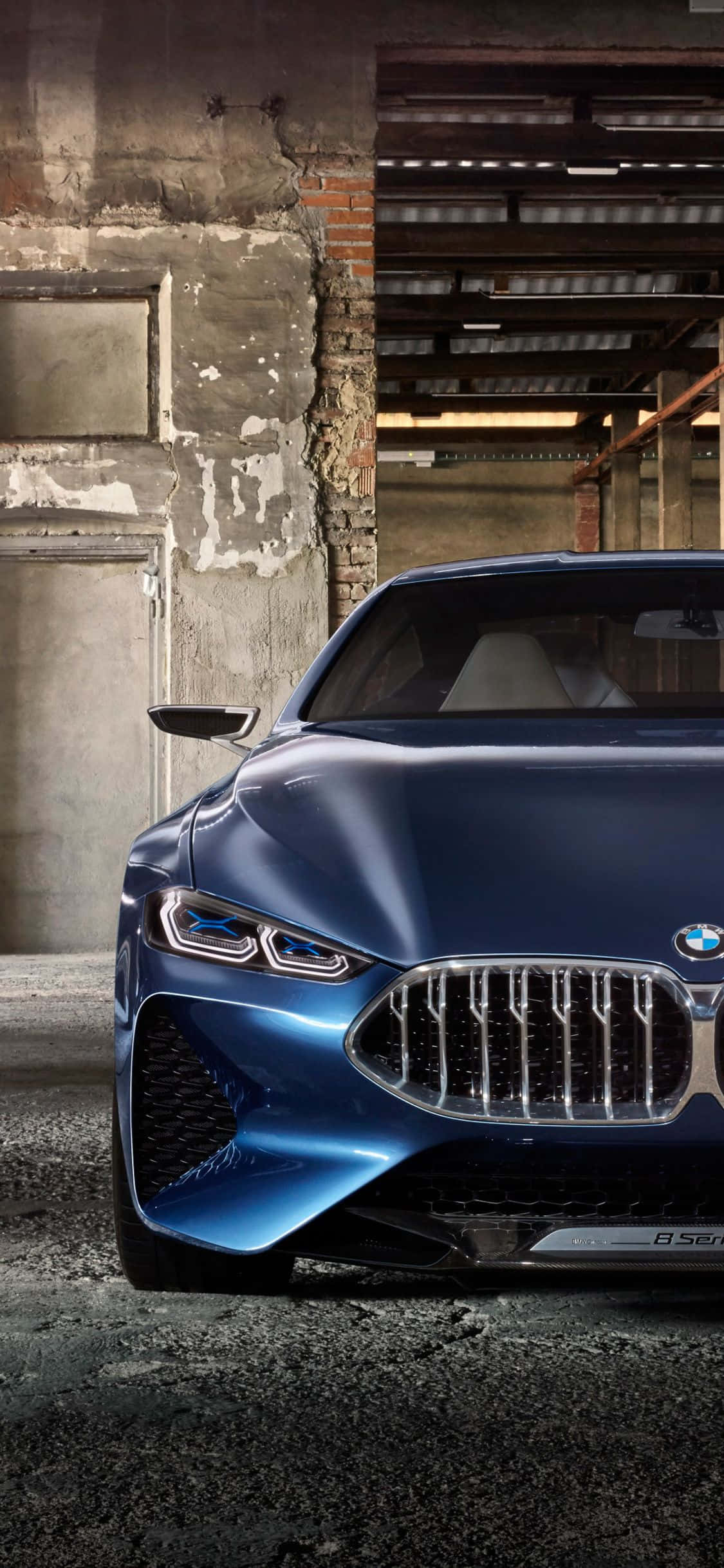 電玩遊戲 桌布 壁紙 — 一輛時尚的藍色BMW概念車，配備發光頭燈，矗立在一個粗糙的工業倉庫中，磚牆和混凝土裸露在外。