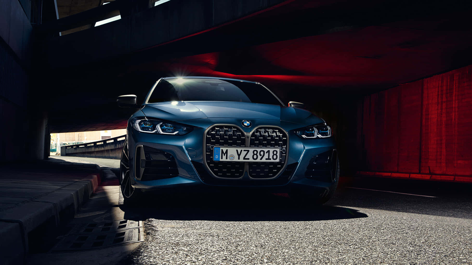 Bmw 440i 桌布 壁紙 — 一輛時尚的藍色BMW跑車停泊在隧道下，帶有戲劇性的紅色燈光和陰影。