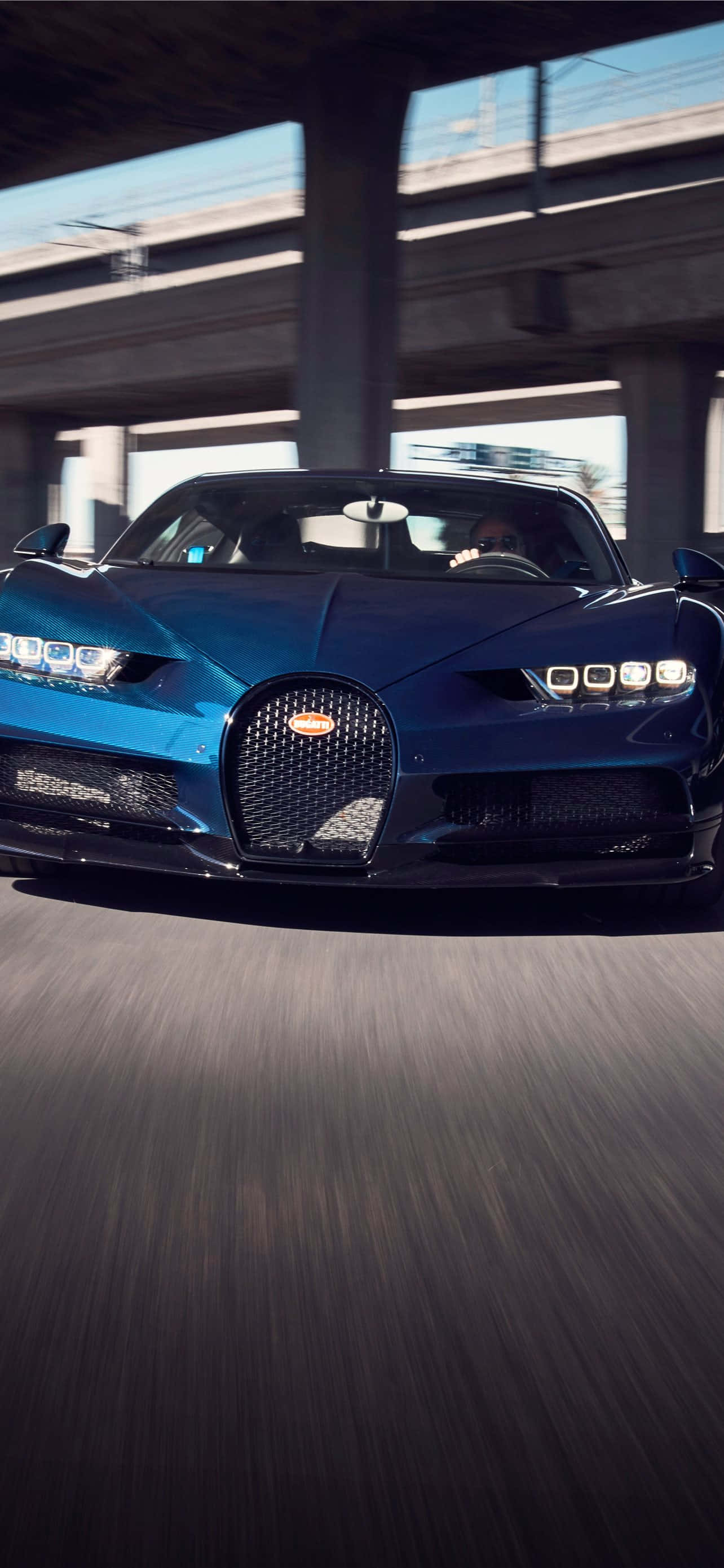 Bugatti Phone 桌布 壁紙 — 一輛時尚的藍色Bugatti超跑在混凝土天橋下行駛，路面呈現動態模糊效果。