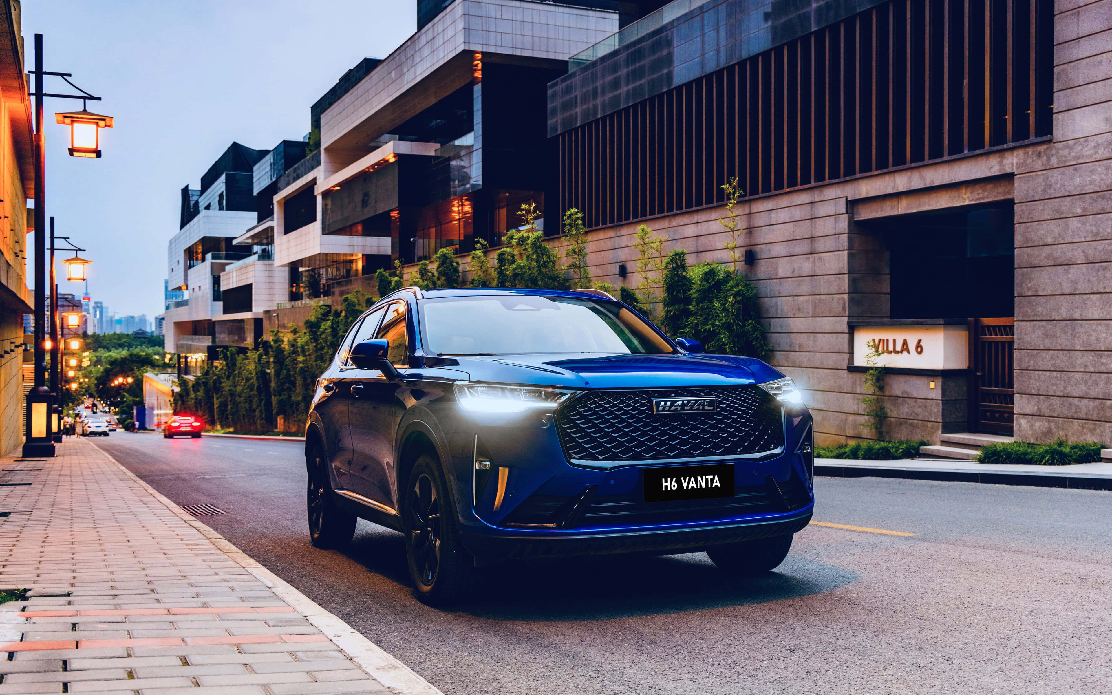 Haval 桌布 壁紙 — 一輛時尚的藍色H6 Vanta SUV在黃昏時分行駛在現代城市街道上，兩旁有發光的街燈和當代建築。