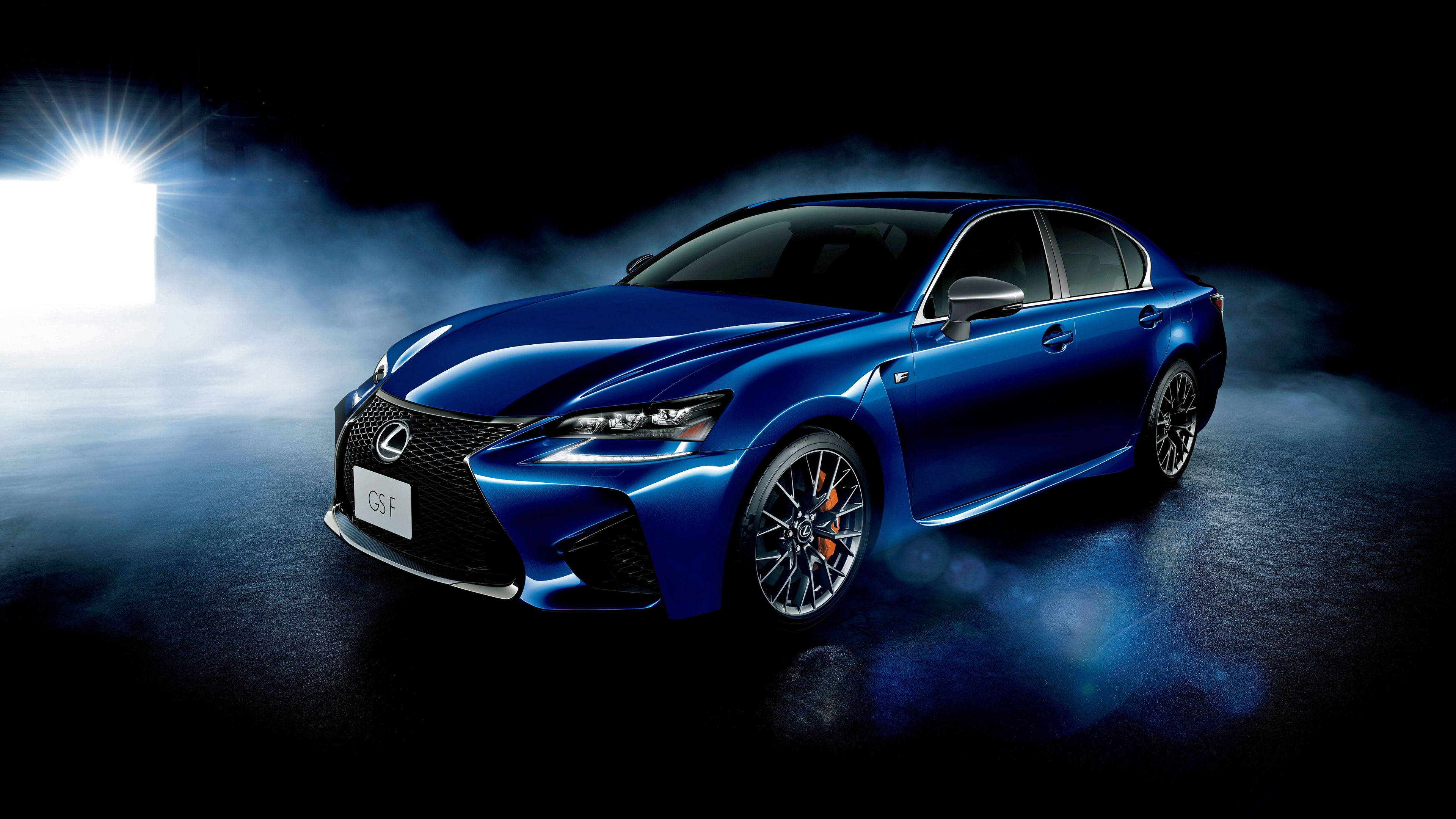 凌志 桌布 壁紙 — 一輛時尚的藍色Lexus GS F轎車在黑暗的攝影棚中，於旋轉煙霧中在聚光燈下閃閃發光。