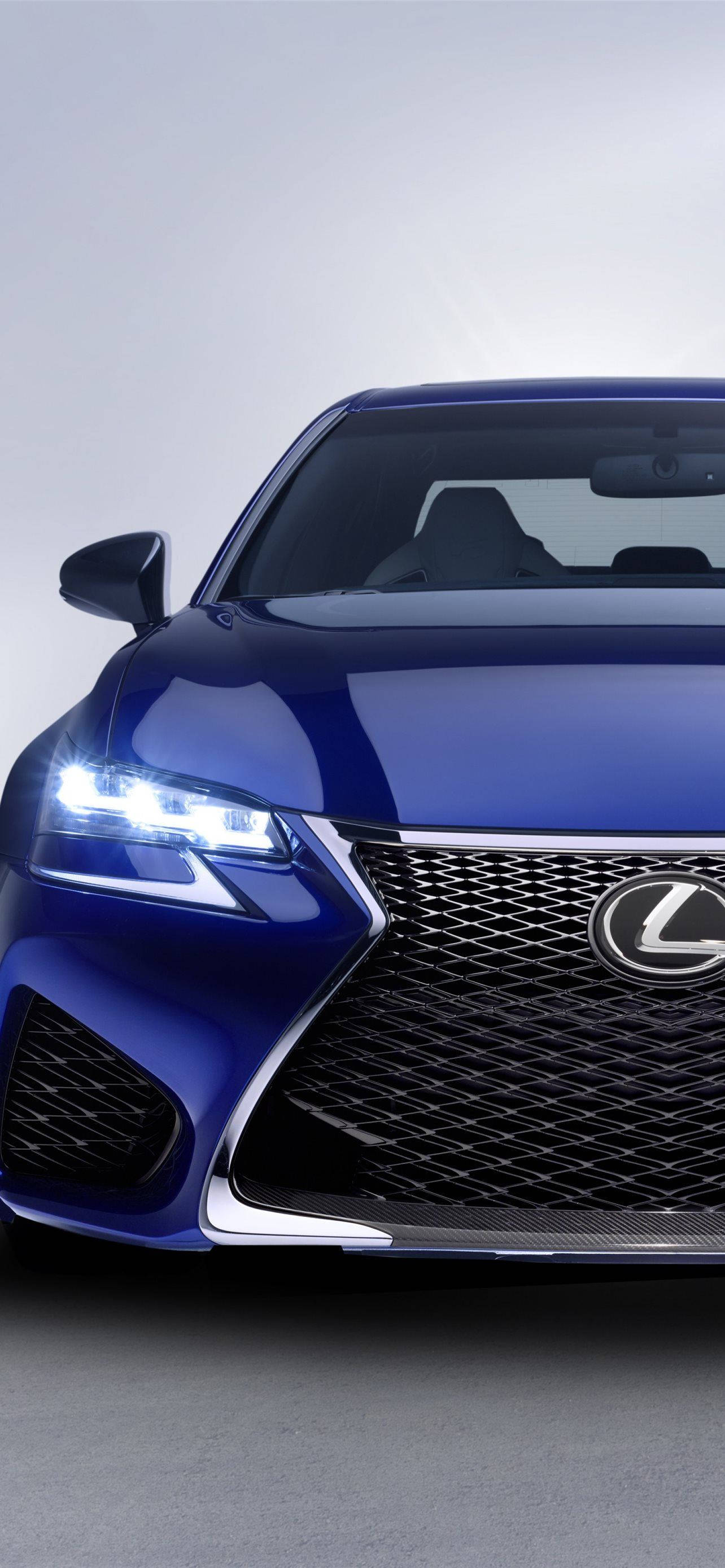 lexus iPhone 桌布 壁紙 — 一輛時尚的藍色Lexus跑車，配備發光頭燈和醒目進氣格柵，背景為簡約灰色工作室。