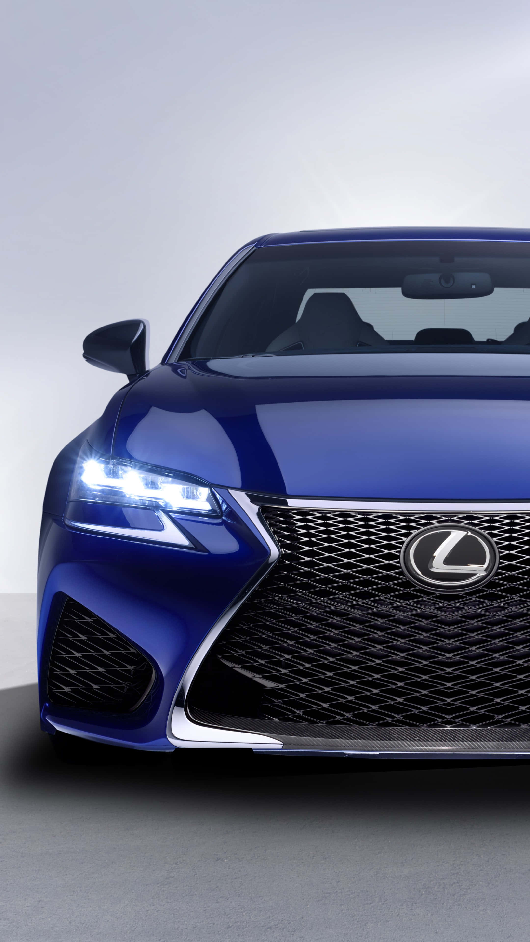 Lexus Gs 桌布 壁紙 — 一輛時尚的藍色Lexus跑車，配備發光頭燈和醒目格柵，以極簡工作室背景為襯托。