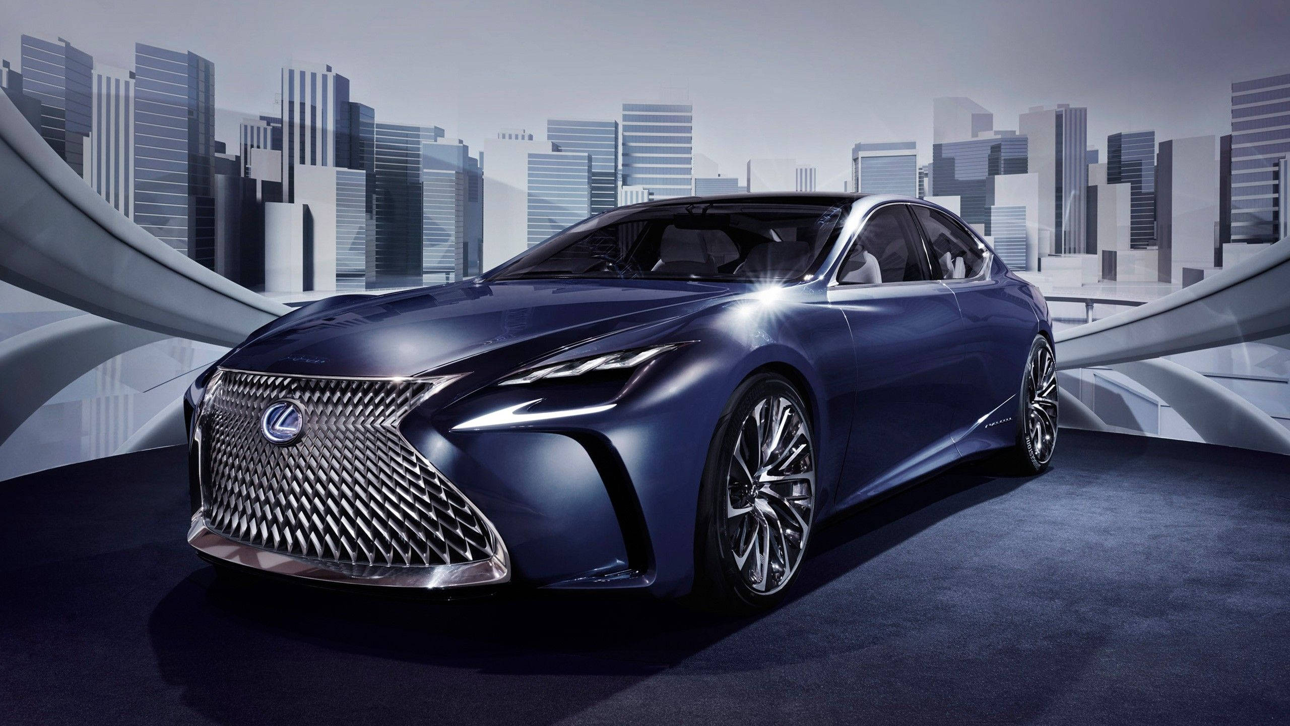 Lexus 標誌 桌布 壁紙 — 一輛時尚的藍色Lexus轎車在攝影棚燈光下閃耀，背景是帶有弧形建築元素的未來城市景觀。