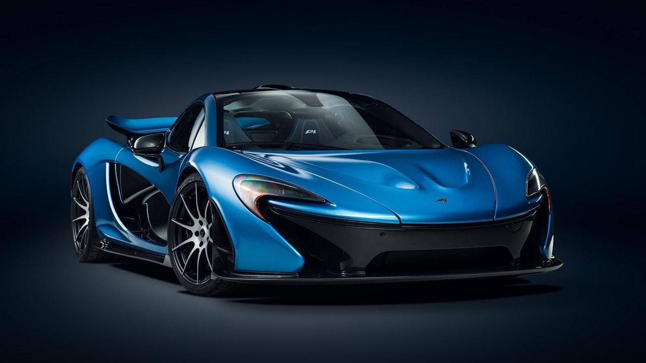 cars 桌布 壁紙 — 一輛時尚的藍色McLaren P1超級跑車在攝影棚燈光下，在深色漸變背景上閃閃發光。