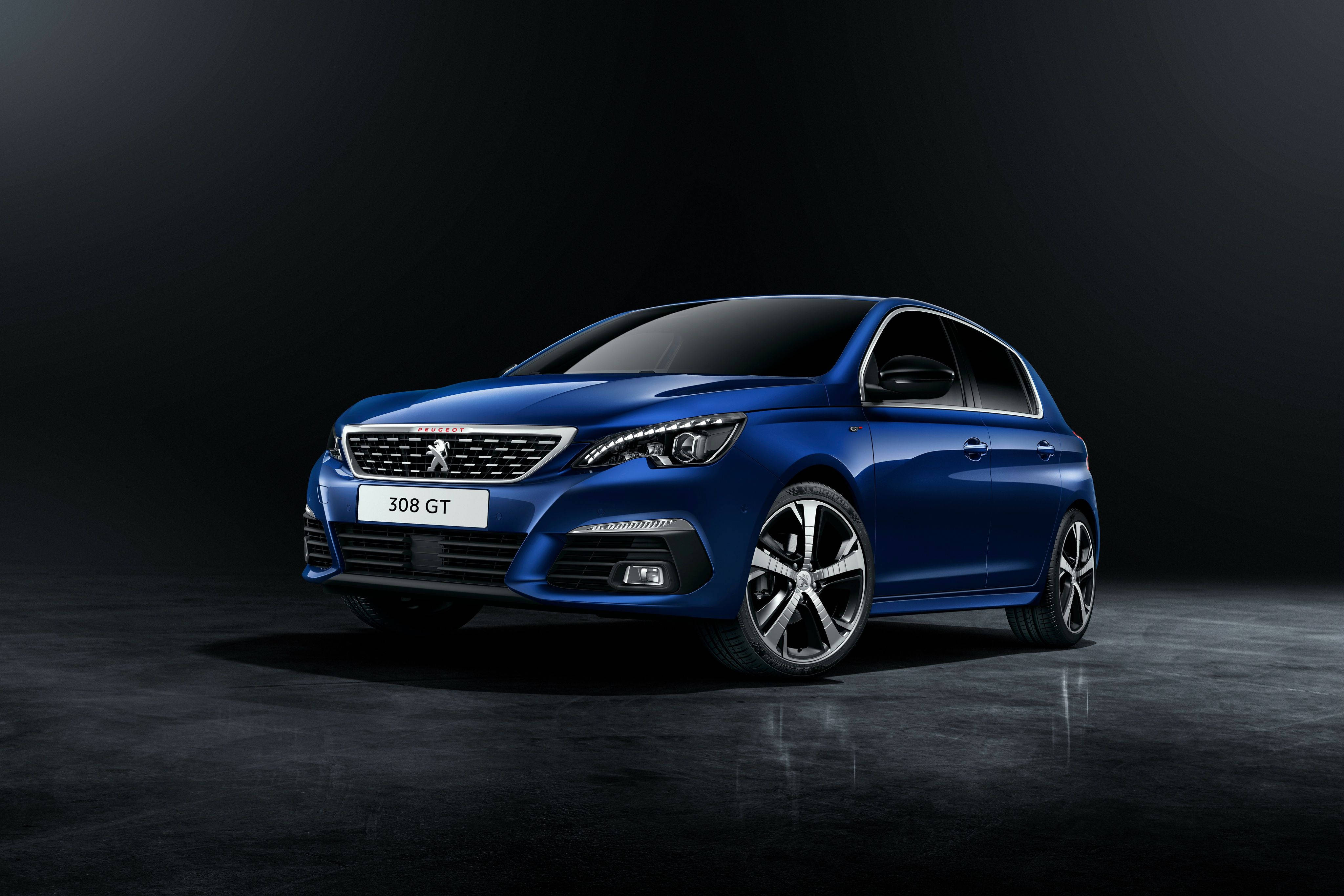 Peugeot 桌布 壁紙 — 一輛時尚的藍色Peugeot 308 GT跑車在攝影棚燈光下，在深色反光地板上閃閃發光。