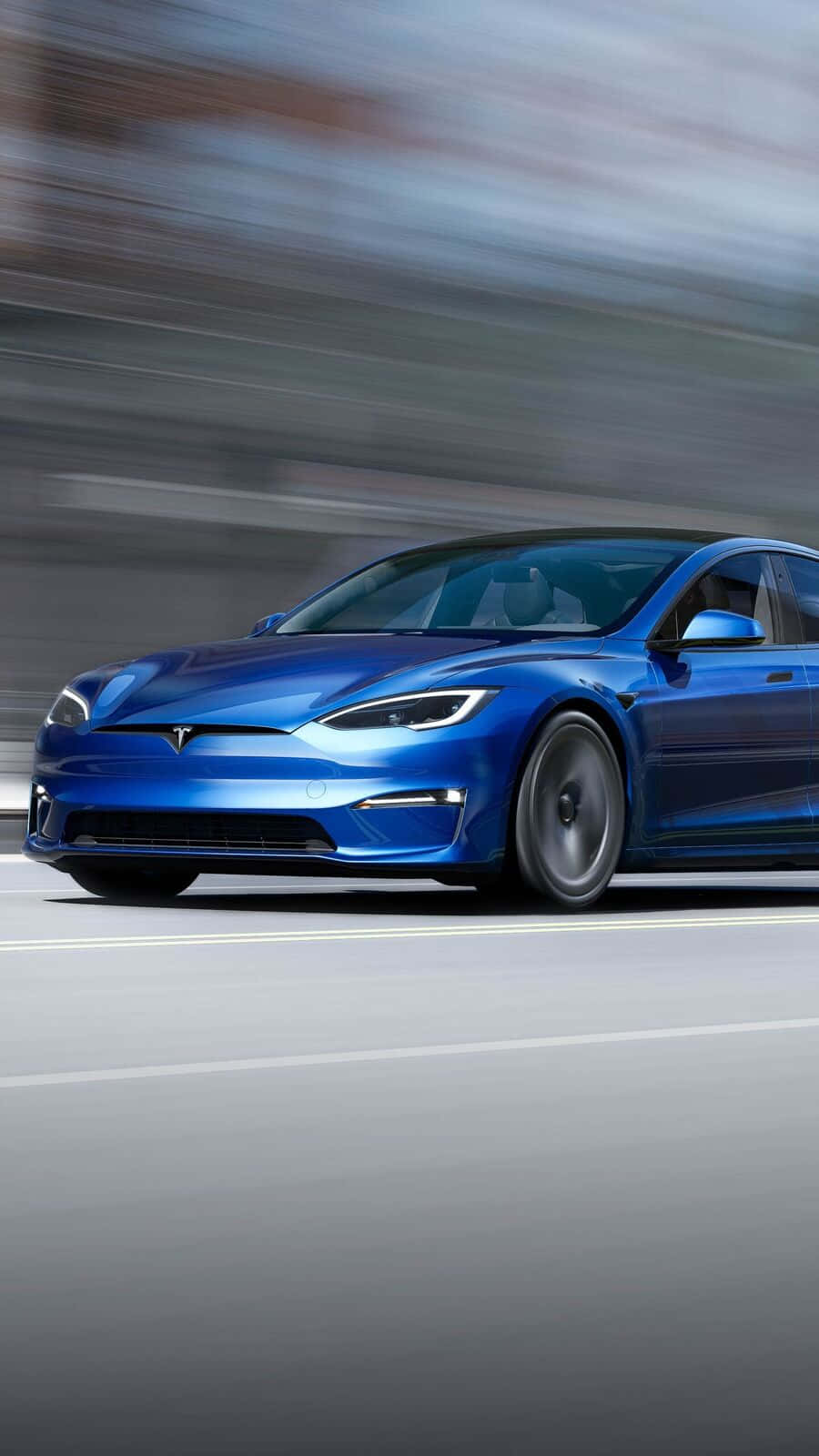 特斯拉 桌布 壁紙 — 一輛時尚的藍色Tesla Model S在模糊的高速公路上奔馳，捕捉動感與現代電動豪華。