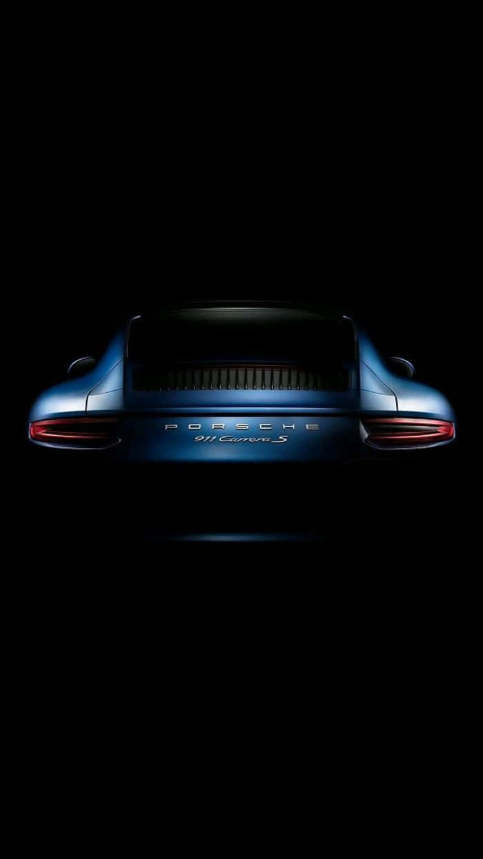 高清 桌布 壁紙 — 一輛時尚的藍色保時捷911 Carrera S在漆黑虛空中從後方發光，尾燈亮起。