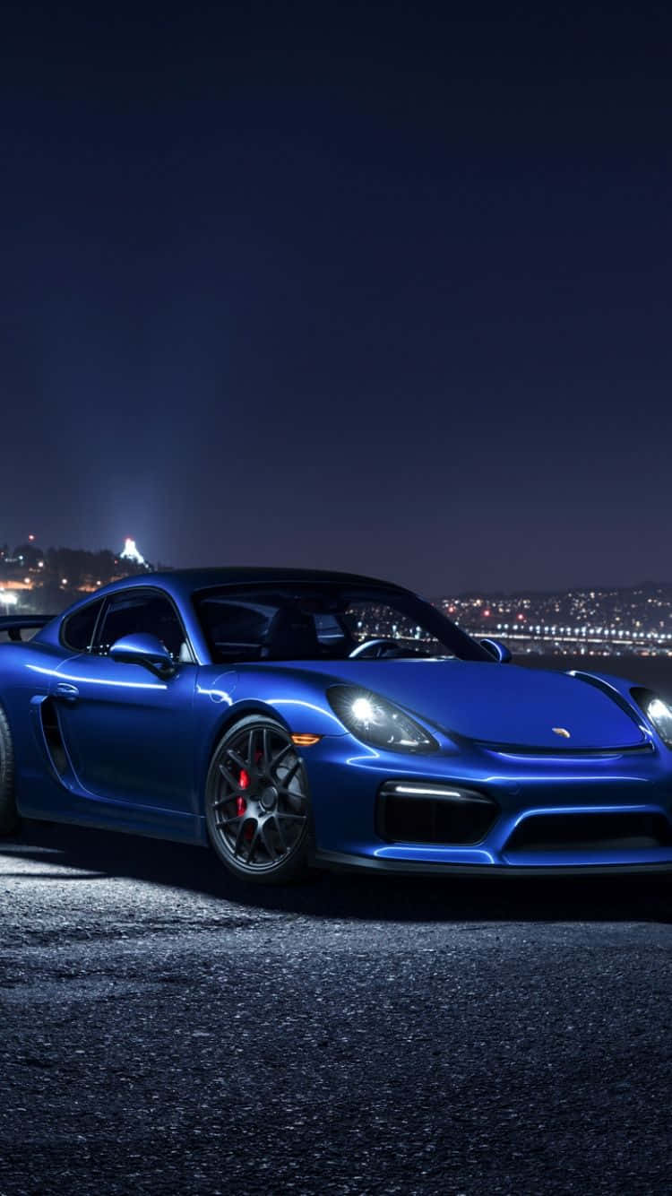 Porsche iPhone 桌布 壁紙 — 一輛時尚的藍色保時捷跑車在夜燈下閃閃發光，遠處的城市景觀閃爍著光芒。