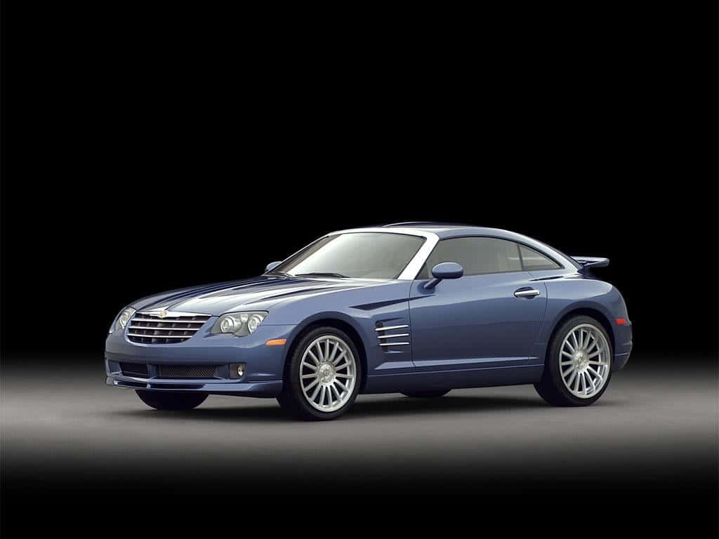 Chrysler Crossfire 桌布 壁紙 — 一輛時尚的藍色克萊斯勒 Crossfire 跑車，配備銀色輪圈和黑色條紋，在深色工作室背景下展示。