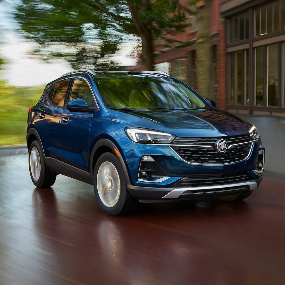 Buick 桌布 壁紙 — 一輛時尚的藍色別克SUV在綠樹成蔭的城市街道上飛馳，動態模糊傳達出動感。